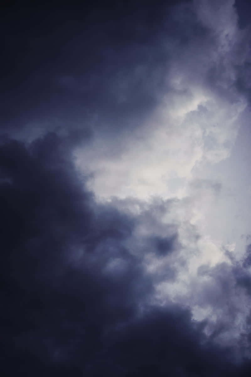 Cloudy 桌布 壁紙 — 戲劇性的深色雲層在陰沉的暮色天空中旋轉，帶有明亮的高光。