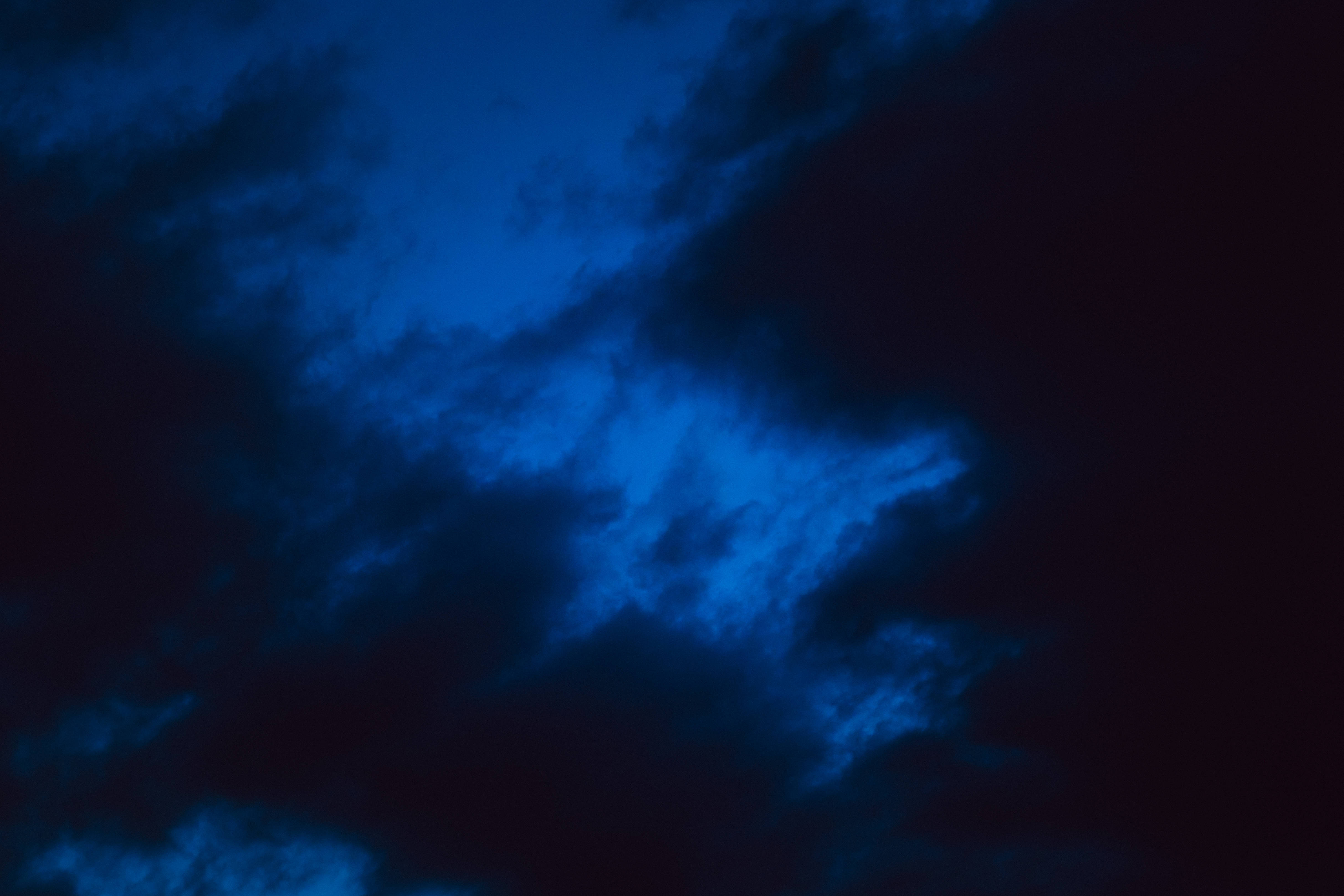 雲朵 桌布 壁紙 — 戲劇性的深藍色雲朵在黑暗的夜空中旋轉，營造出陰鬱的氛圍。