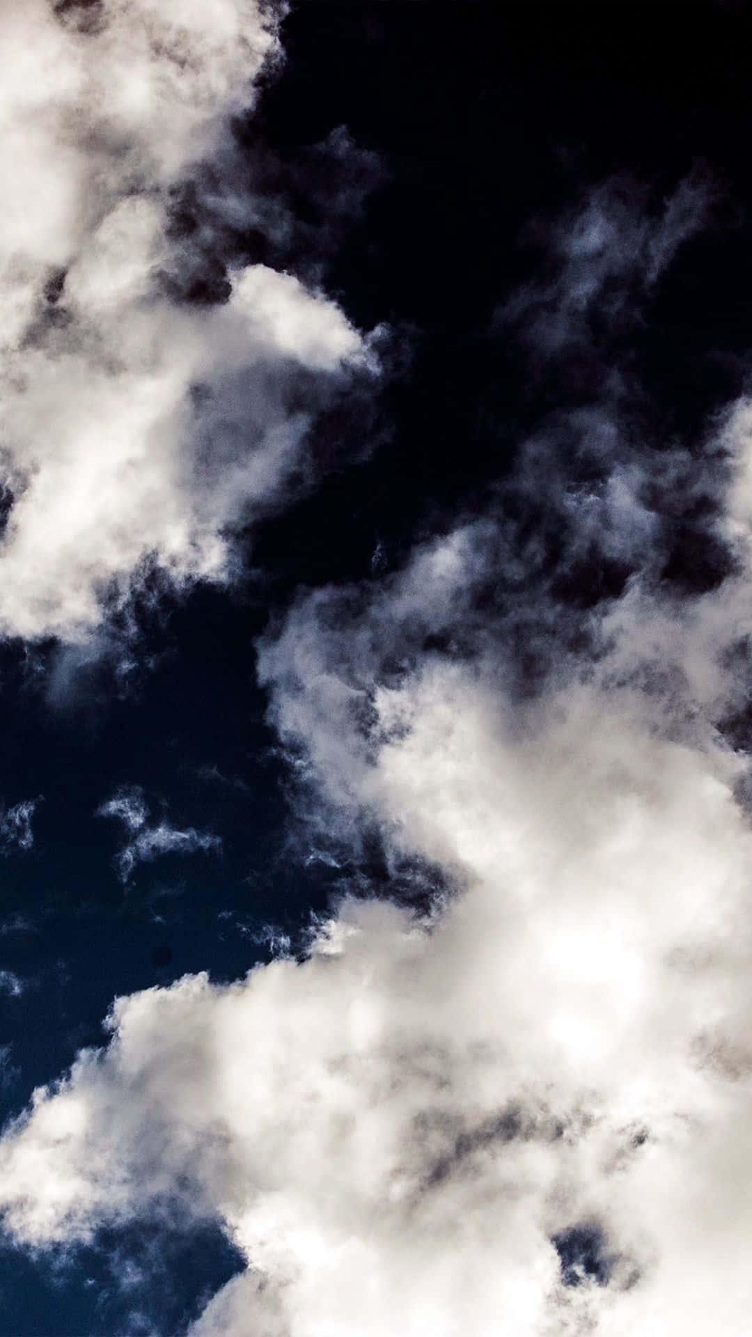 Cloud Aesthetic 桌布 壁紙 — 戲劇性的白色雲朵在深靛藍色的天空中旋轉，形成高對比的天體場景。
