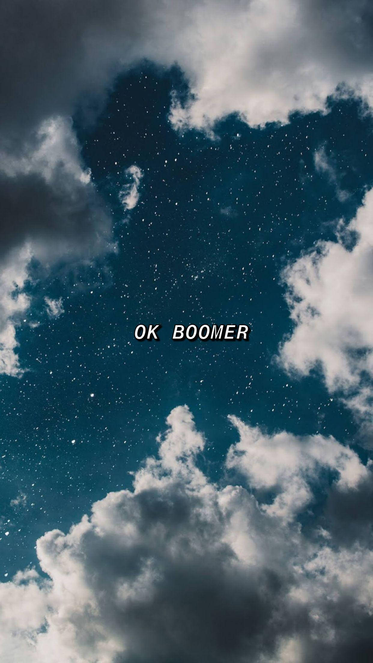 Okay 桌布 壁紙 — 戲劇性的雲層中透出星空夜空，白色文字 OK BOOMER 置中。