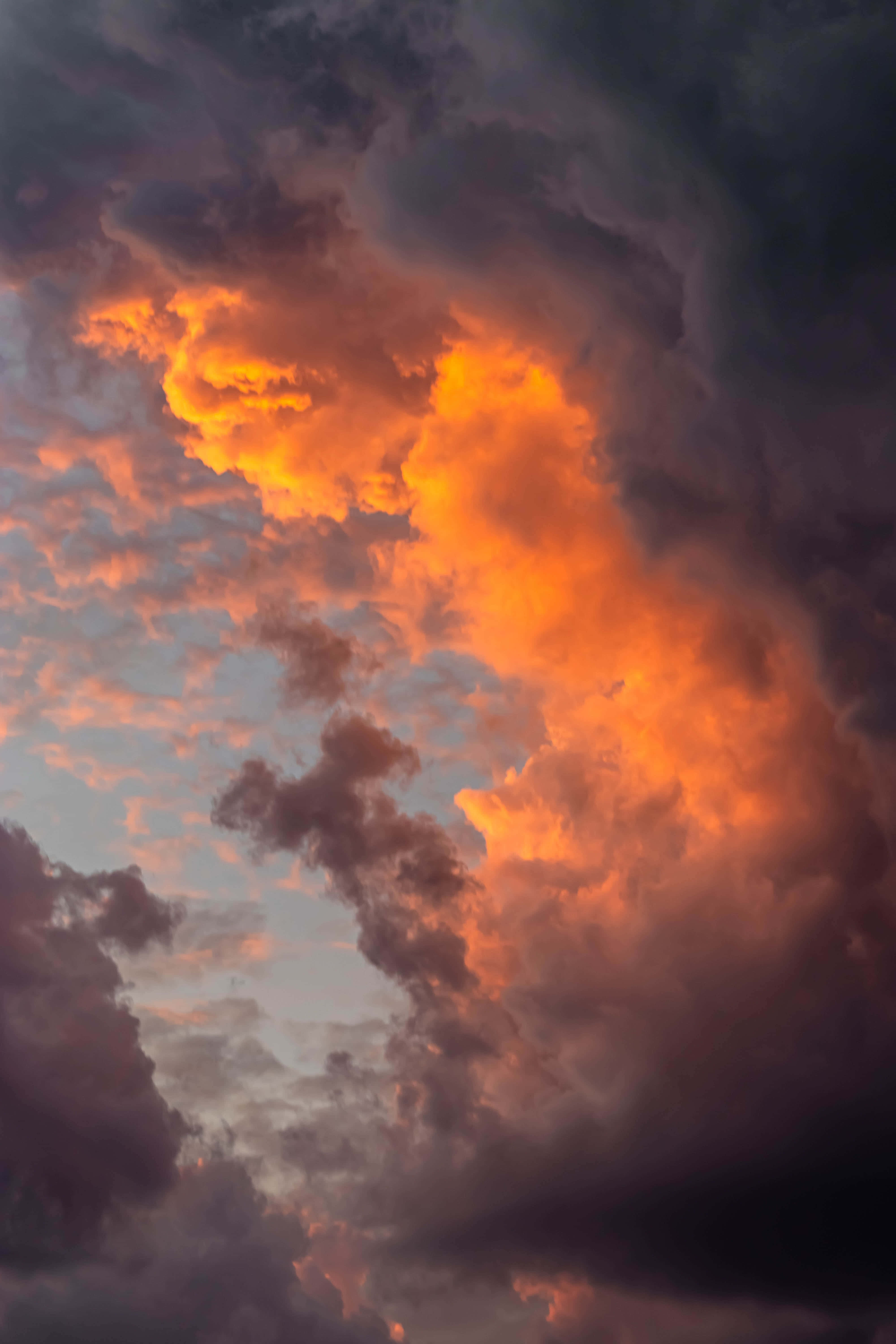 Aesthetic Night Sky 桌布 壁紙 — 戲劇性的雲層在暮色天空中燃起熾熱的橙色和深紫色調。