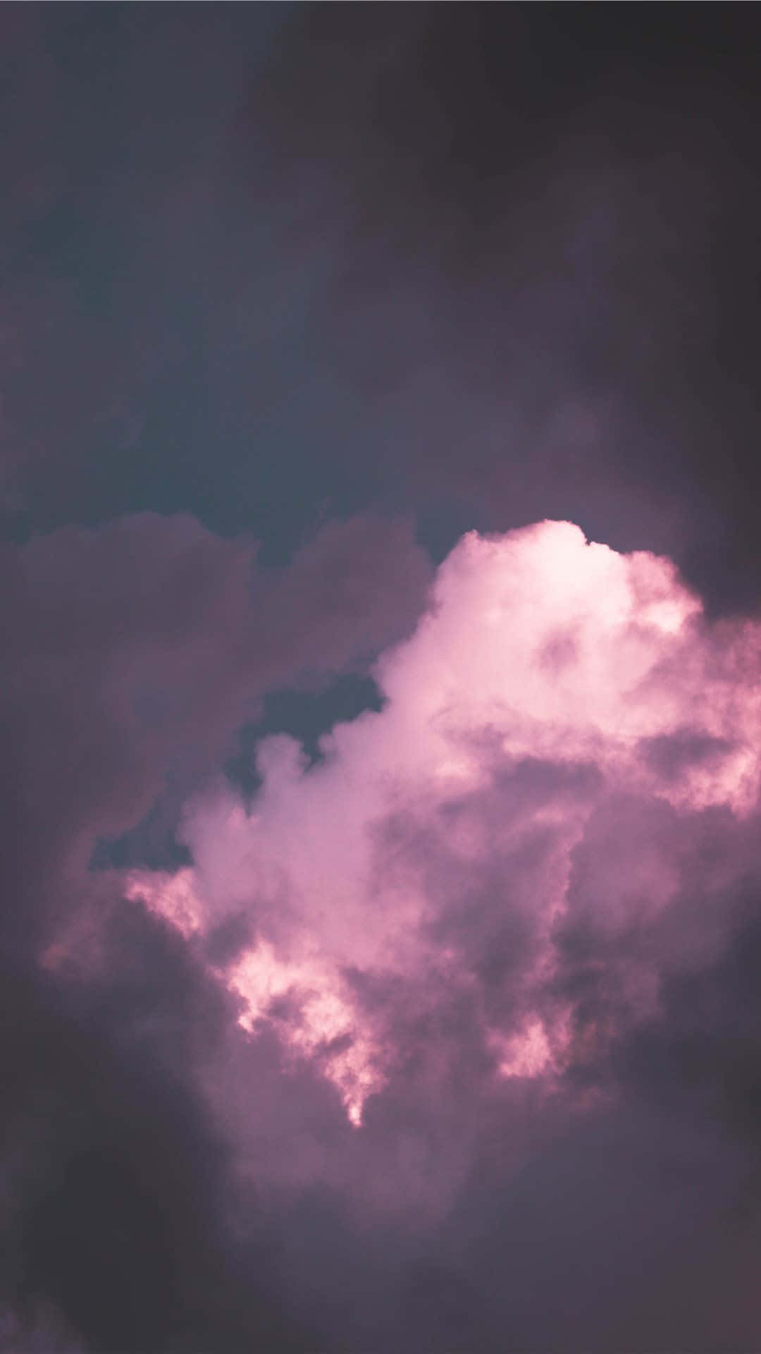 Vaporwave iPhone 桌布 壁紙 — 戲劇性的雲層在深紫色暮色天空中散發出柔和的粉紅色光芒。