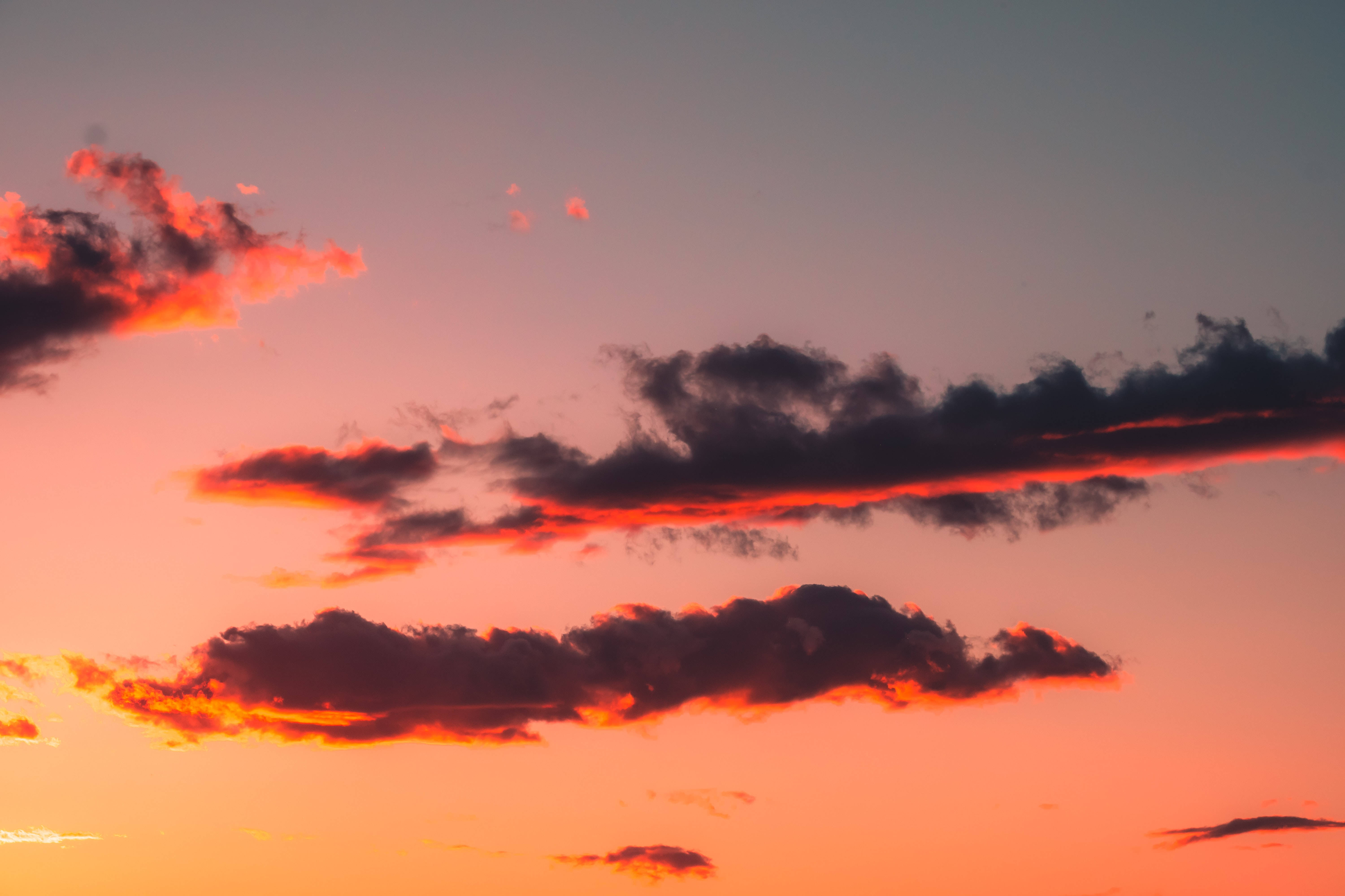 Beautiful Sky 桌布 壁紙 — 戲劇性的雲彩劃過充滿活力的橙色和粉紅色日落天空，帶有深紫色漸變。