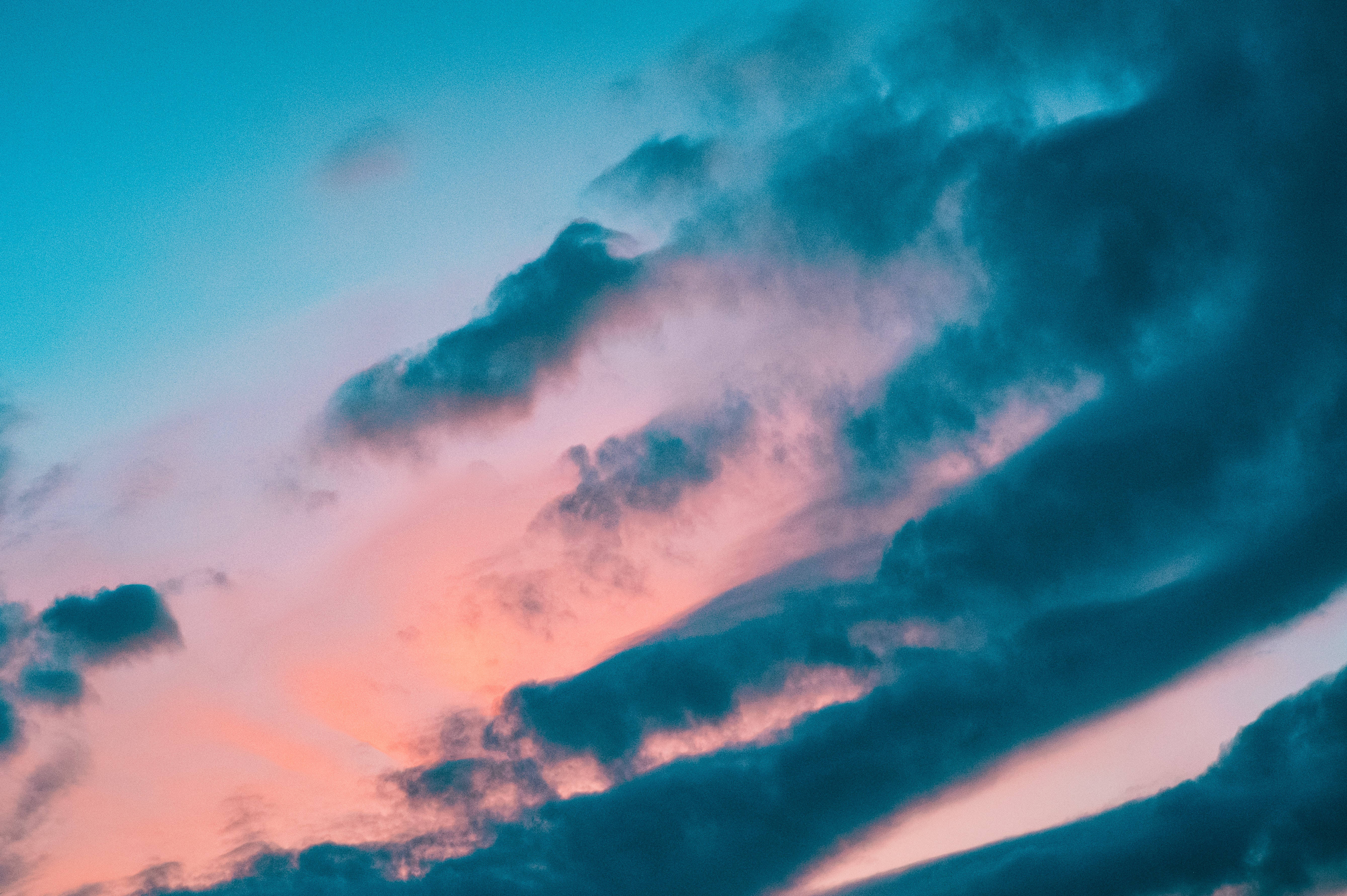 Beautiful Sky 桌布 壁紙 — 戲劇性的雲彩劃過黃昏的天空，天空被塗上鮮豔的粉紅色和深藍綠色調。
