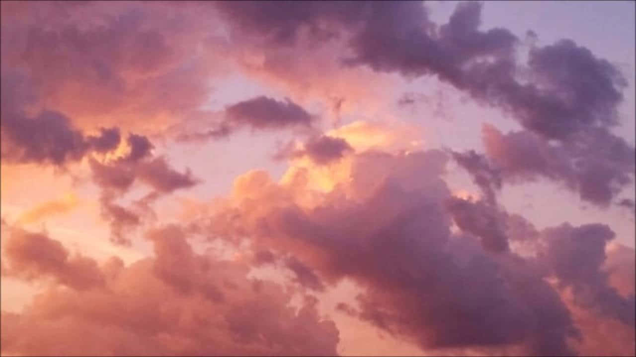 雲朵 桌布 壁紙 — 戲劇性的雲朵在夕陽西下時泛起火橙色和深紫色的色彩。