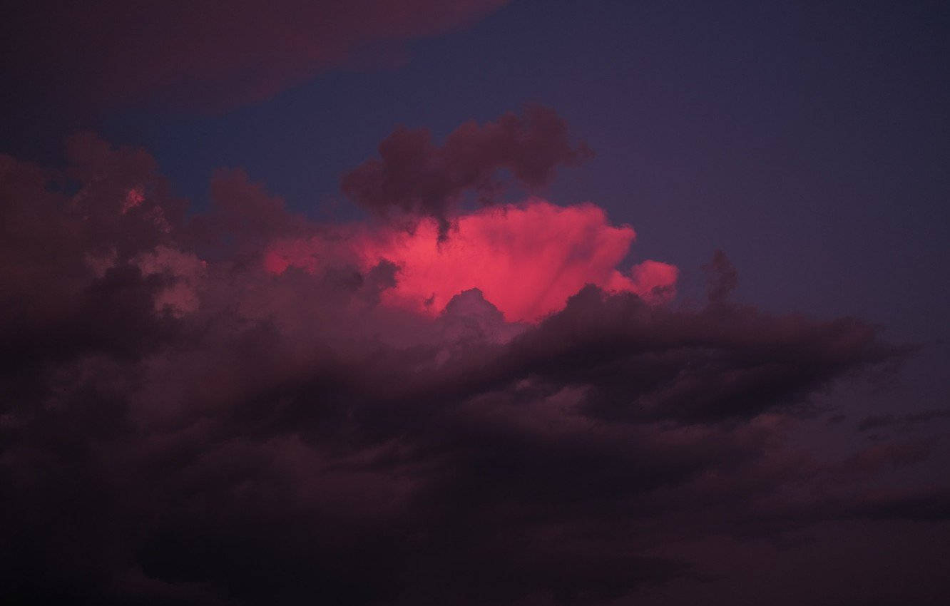 Pink Clouds 桌布 壁紙 — 戲劇性的雲朵在深紫色暮色天空中散發出火熱的粉紅色光芒。