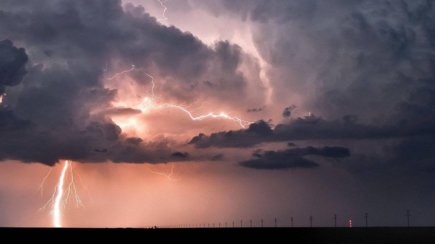 Storm 桌布 壁紙 — 戲劇性的雷暴，生動的閃電照亮了黑暗的雲層，地平線平坦，有電線。