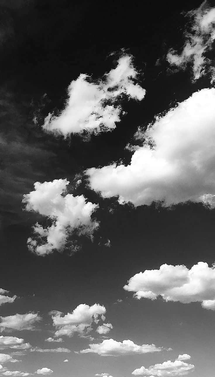 Black And White Sky 桌布 壁紙 — 戲劇性的高對比黑白雲朵在陰鬱的天空中飄移，帶有深沉的陰影和明亮的高光。