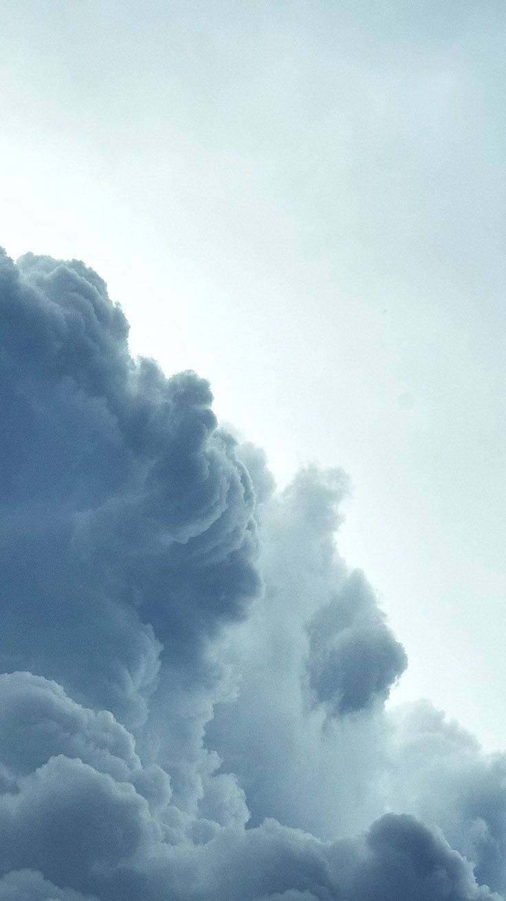 雲朵 桌布 壁紙 — 戲劇性的高聳雲層以冷色調的藍色和灰色充滿天空，柔和的光線透過其紋理形態過濾。