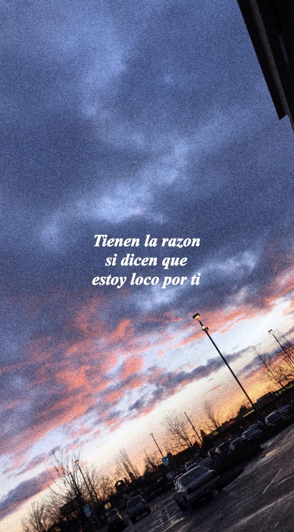 Cuco 桌布 壁紙 — 戲劇性的黃昏天空，帶有火熱的橙色雲彩，停車場在漸暗的光線中呈現剪影。