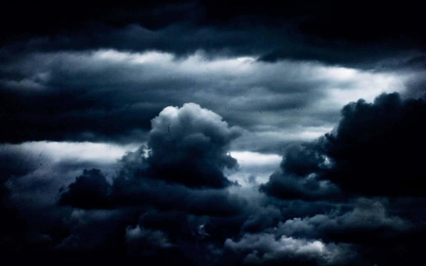 Dark Clouds 桌布 壁紙 — 戲劇性的黑暗風暴雲翻滾，不祥的光芒穿透陰沉的天空。
