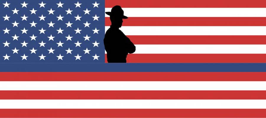 USA flag iPhone 桌布 壁紙 — 戴帽人物的剪影，映襯著美國國旗大膽的紅、白、藍條紋和星星。