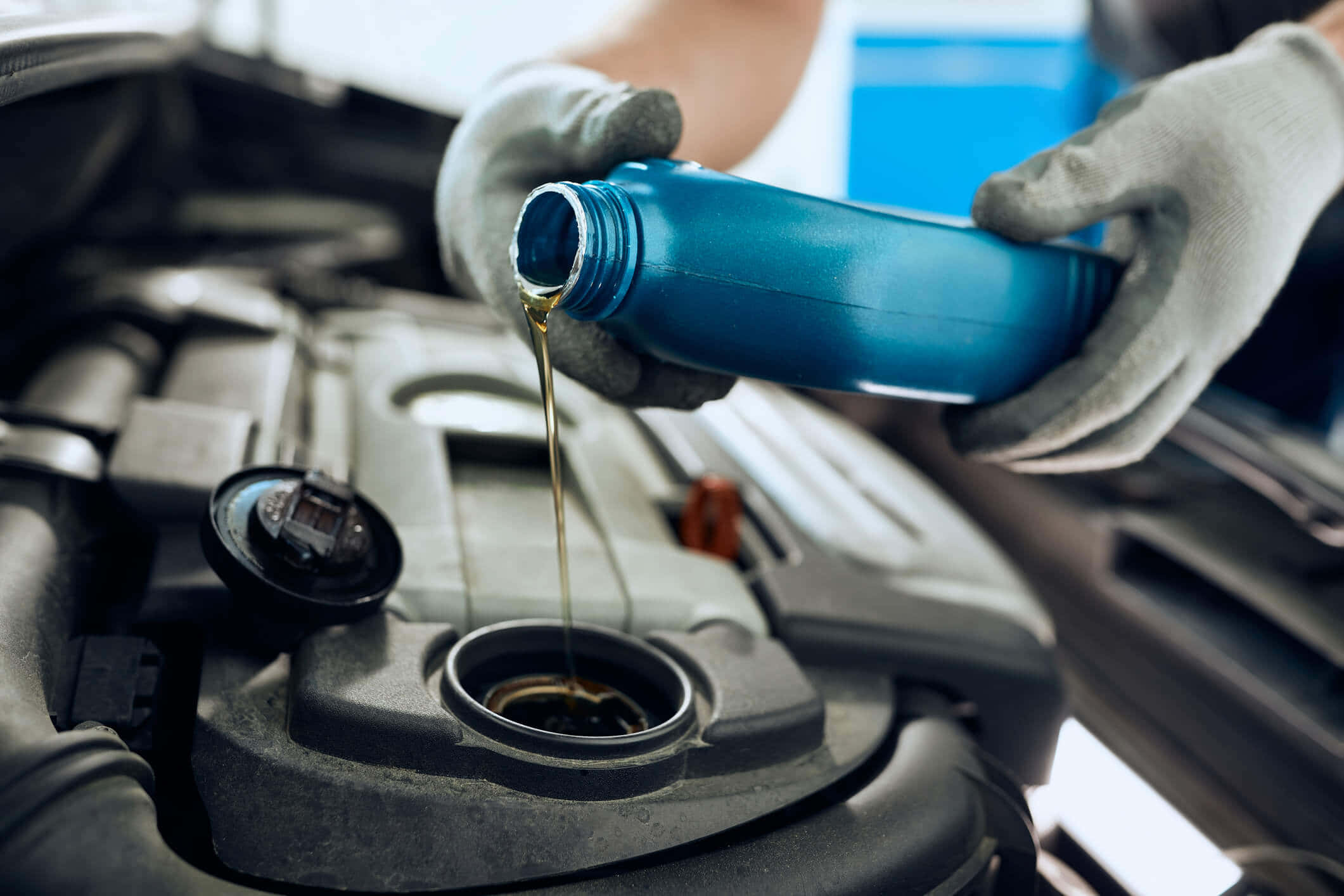 Engine Oil 桌布 壁紙 — 戴手套的手將金色引擎機油從藍色瓶子倒入打開的汽車引擎室。