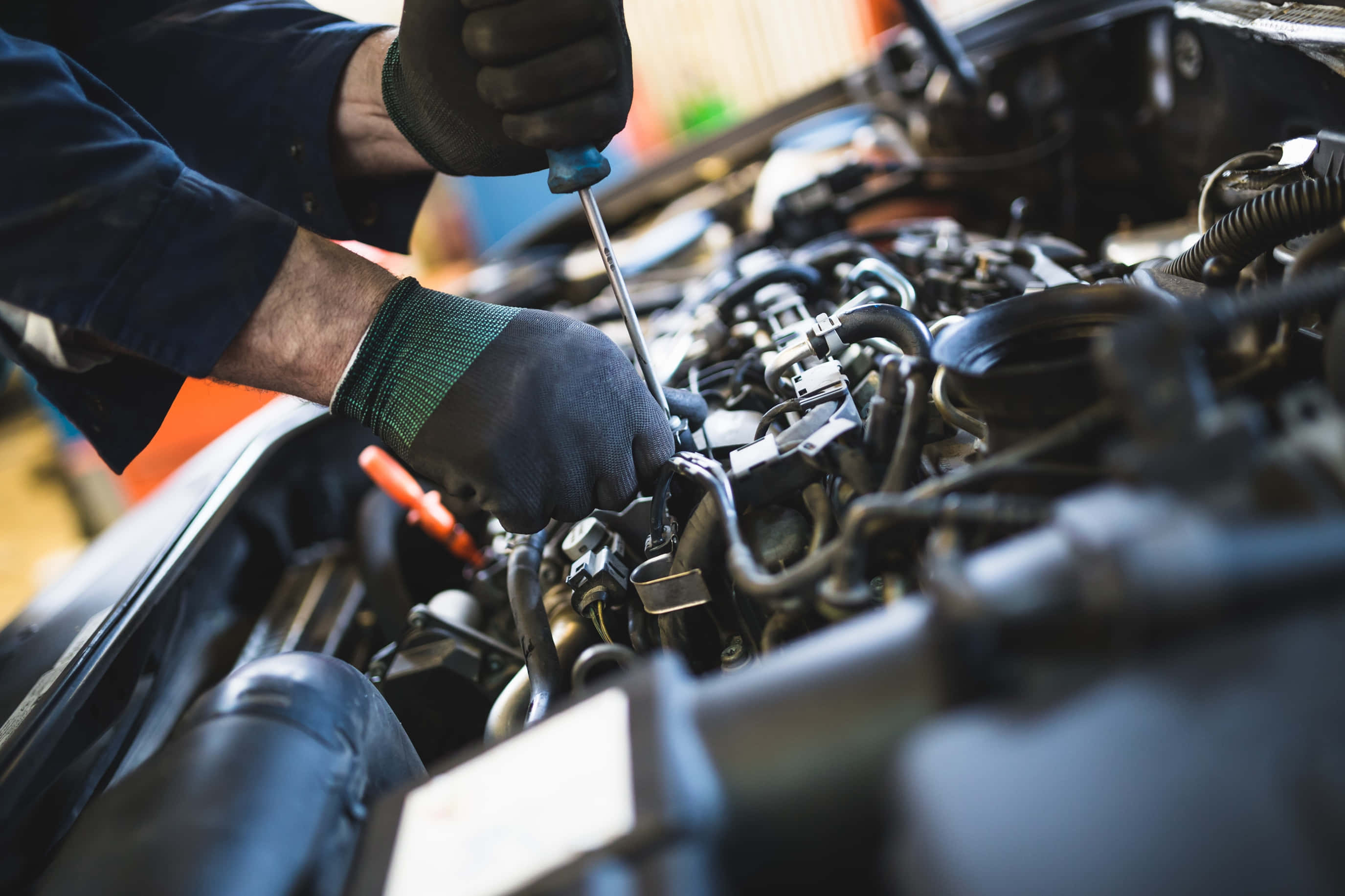 Car Repair 桌布 壁紙 — 戴手套的技工用螺絲起子調整汽車引擎室內的零件。