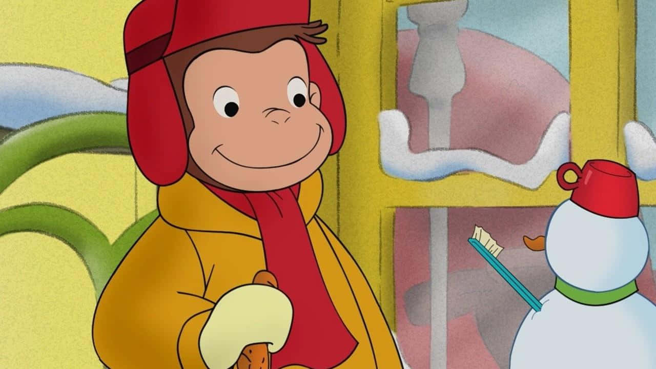 Curious George 桌布 壁紙 — 戴紅帽穿黃色外套的好奇喬治，在窗外有雪人的雪窗前微笑著拿著餅乾。