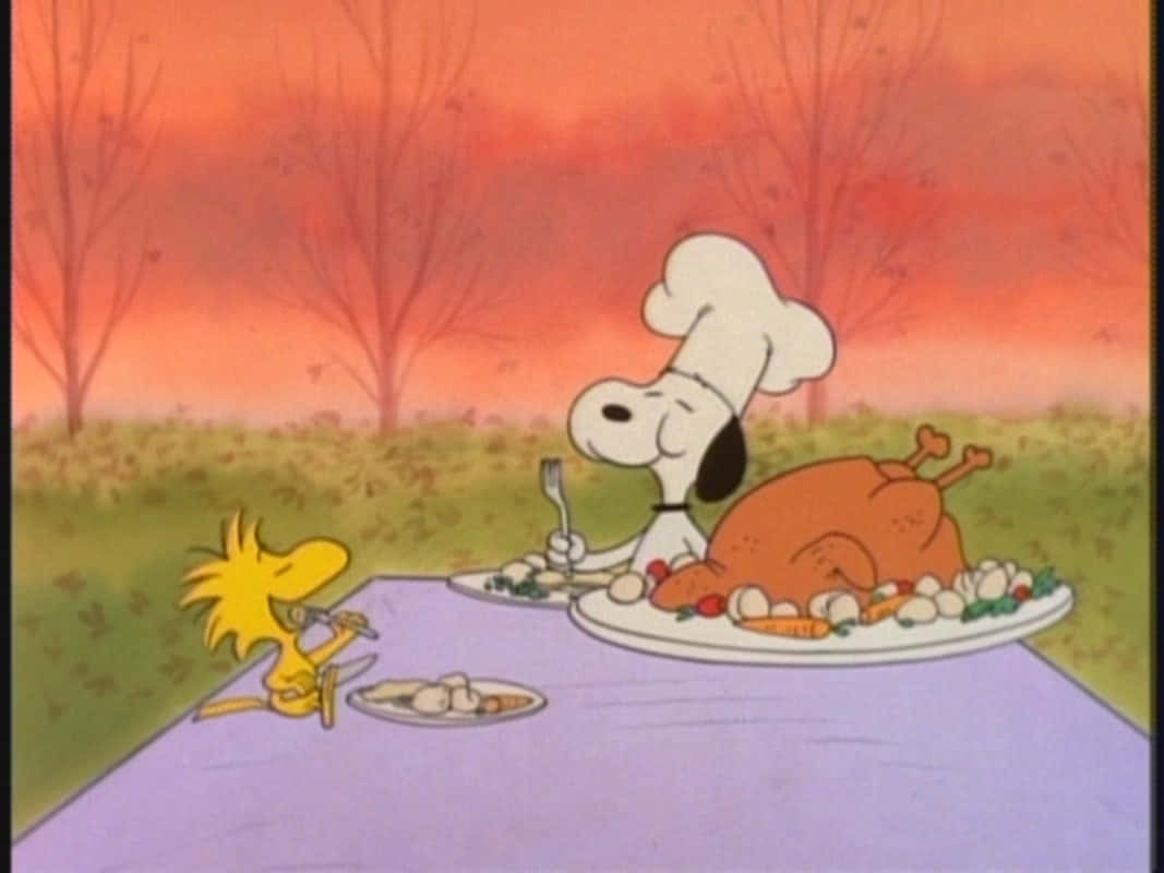 Snoopy Thanksgiving 桌布 壁紙 — 戴著廚師帽的史努比與胡士托在戶外野餐桌旁，在橙色夕陽天空下吃火雞。
