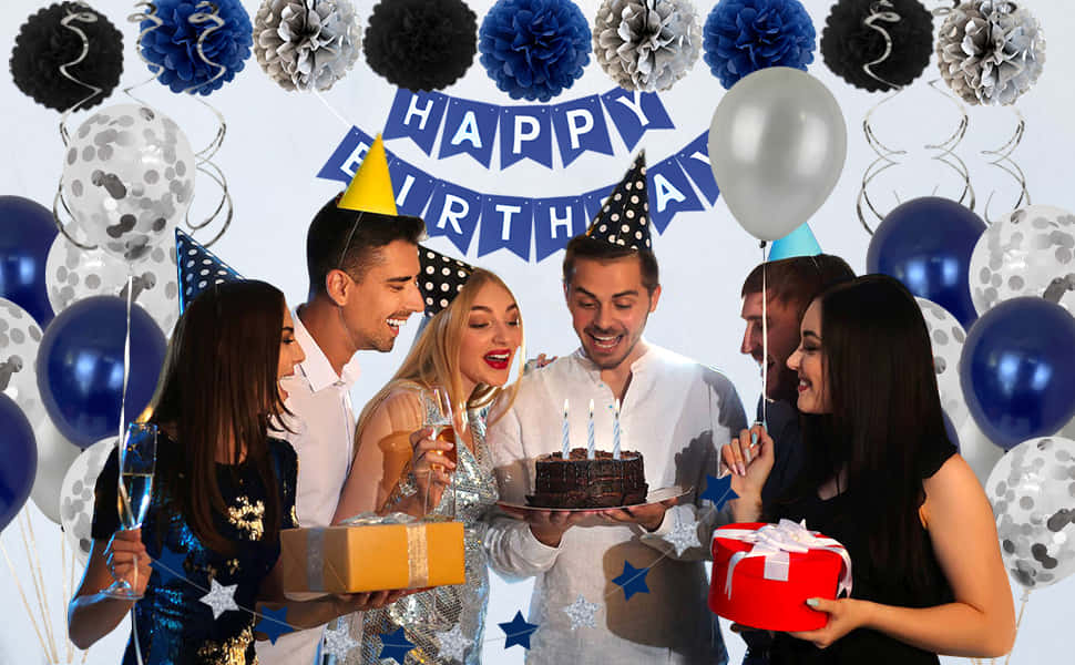 Birthday Party 桌布 壁紙 — 戴著派對帽的朋友們聚集在一個有蠟燭的巧克力蛋糕周圍，下方有藍色銀色氣球和一個「生日快樂」的橫幅。
