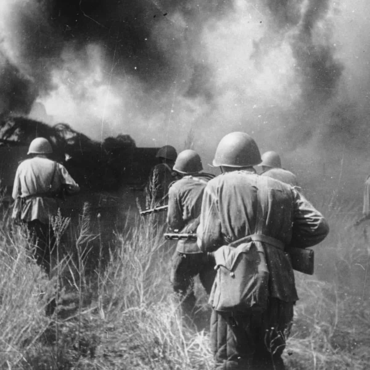 戰爭動圖 桌布 壁紙 — 戴頭盔的士兵穿過高草，向被濃煙和火焰吞沒的戰場行進。
