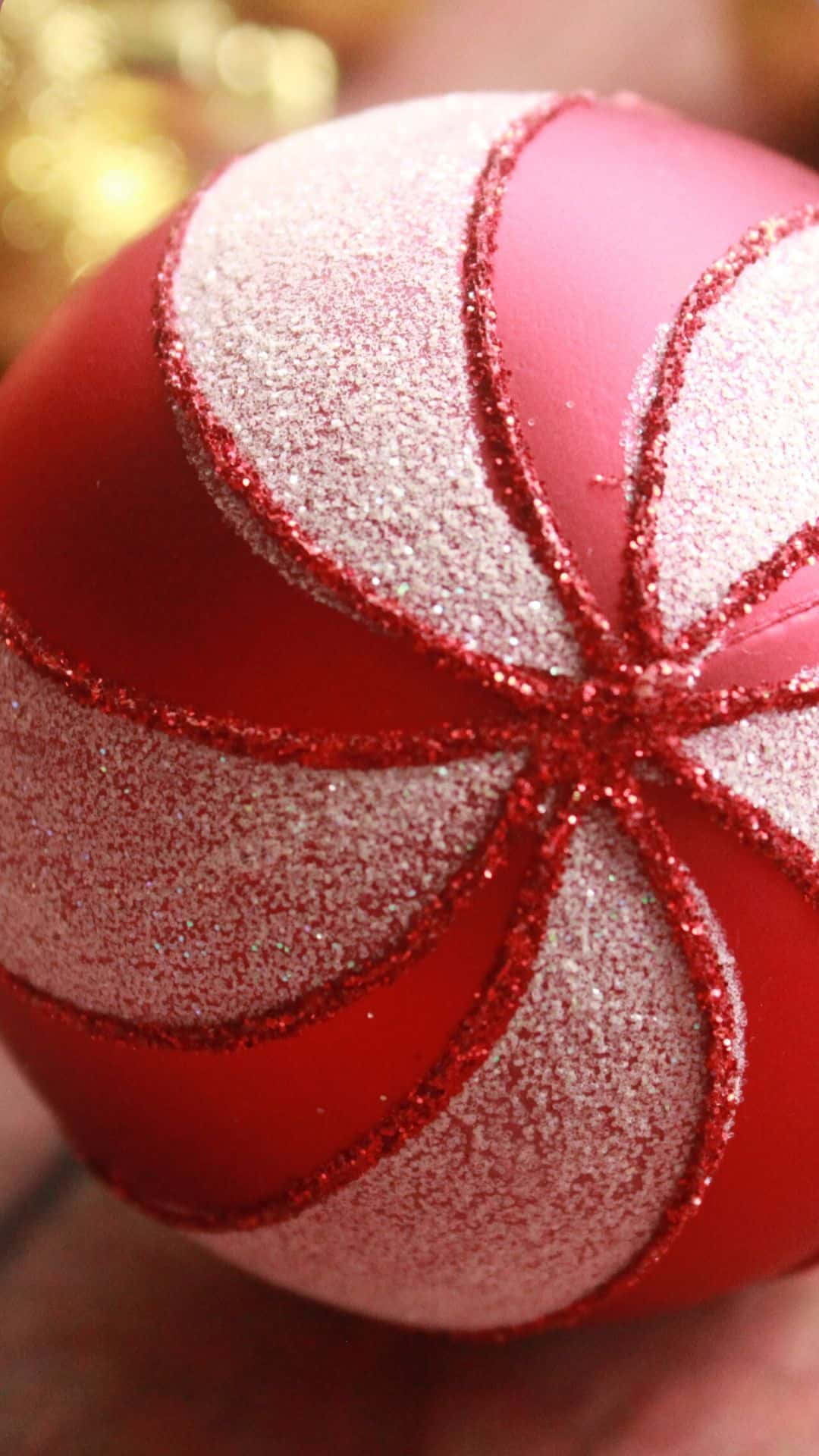 Red Aesthetic Christmas 桌布 壁紙 — 手持紅色和銀色閃亮聖誕裝飾品的特寫，帶有紅色亮粉邊緣。