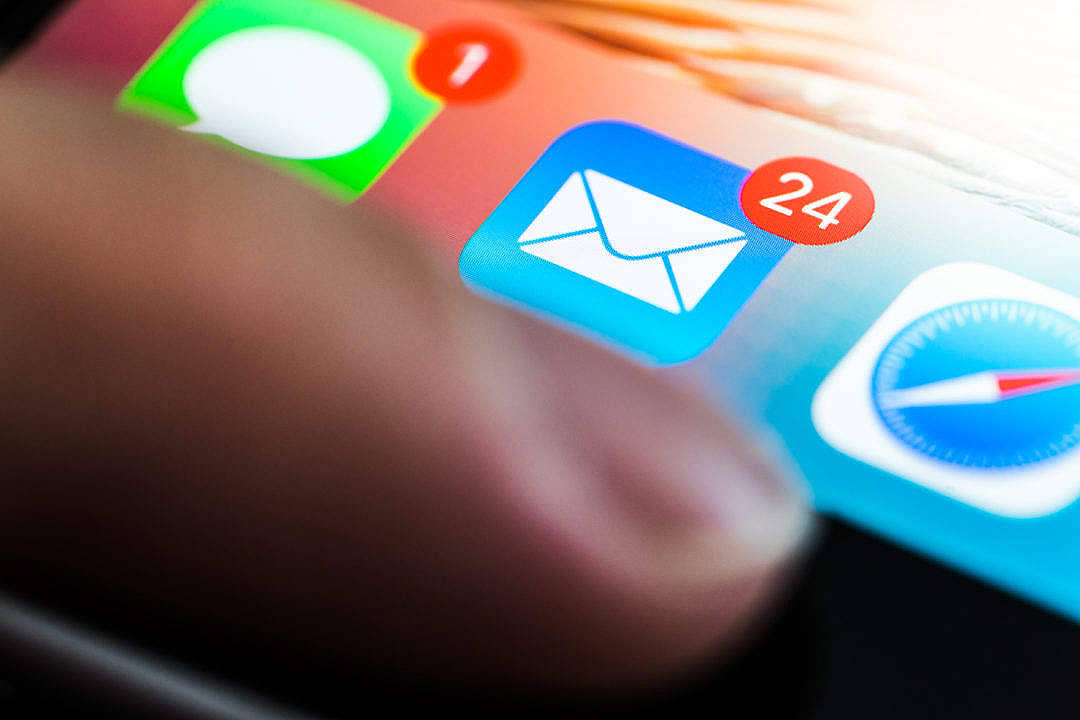Email 桌布 壁紙 — 手指懸浮在顯示未讀通知的應用程式圖示的智慧型手機螢幕上方的特寫。
