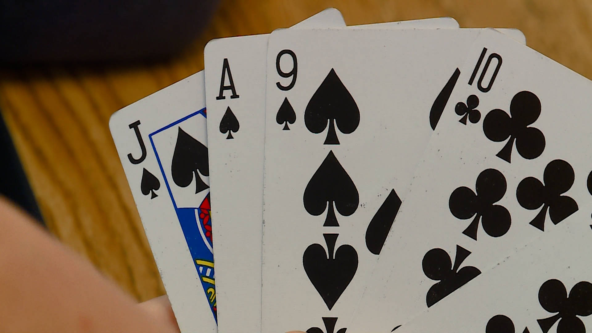 Casino 桌布 壁紙 — 手牌中四張撲克牌的近距離特寫，顯示黑桃和梅花的J、A、9和10。