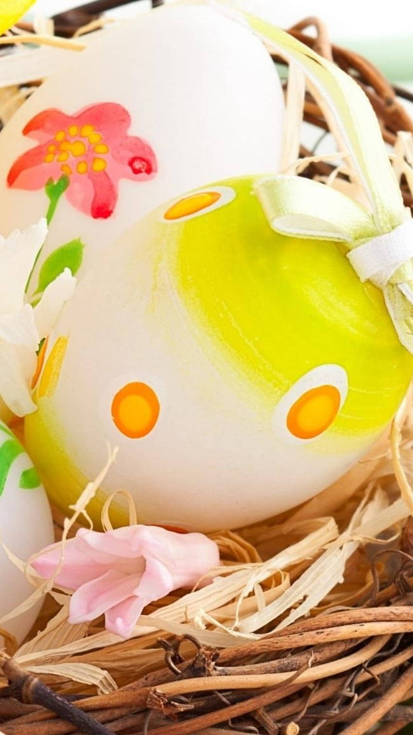 Easter Phone 桌布 壁紙 — 手繪復活節彩蛋，帶有花卉和圓點圖案，放在一個鋪有稻草和粉紅色花朵的編織籃子裡。