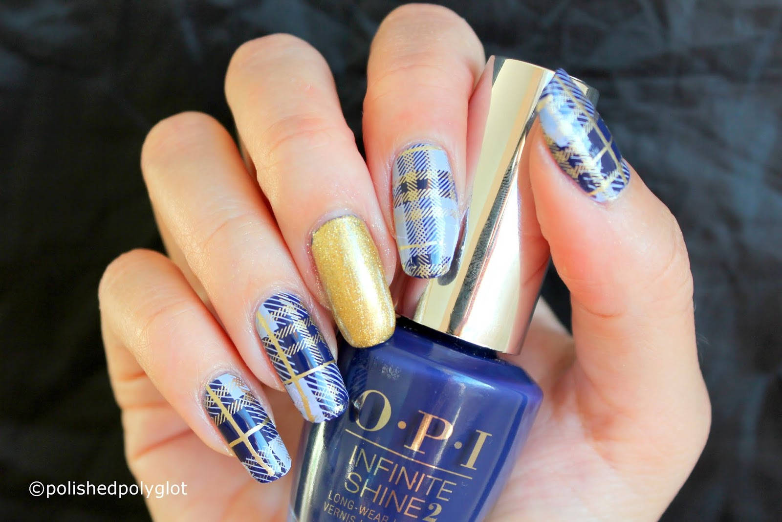 Nail Polish 桌布 壁紙 — 手部帶有格紋和金色亮片指甲，在深色紋理背景前握著一瓶藍色OPI Infinite Shine 2指甲油。