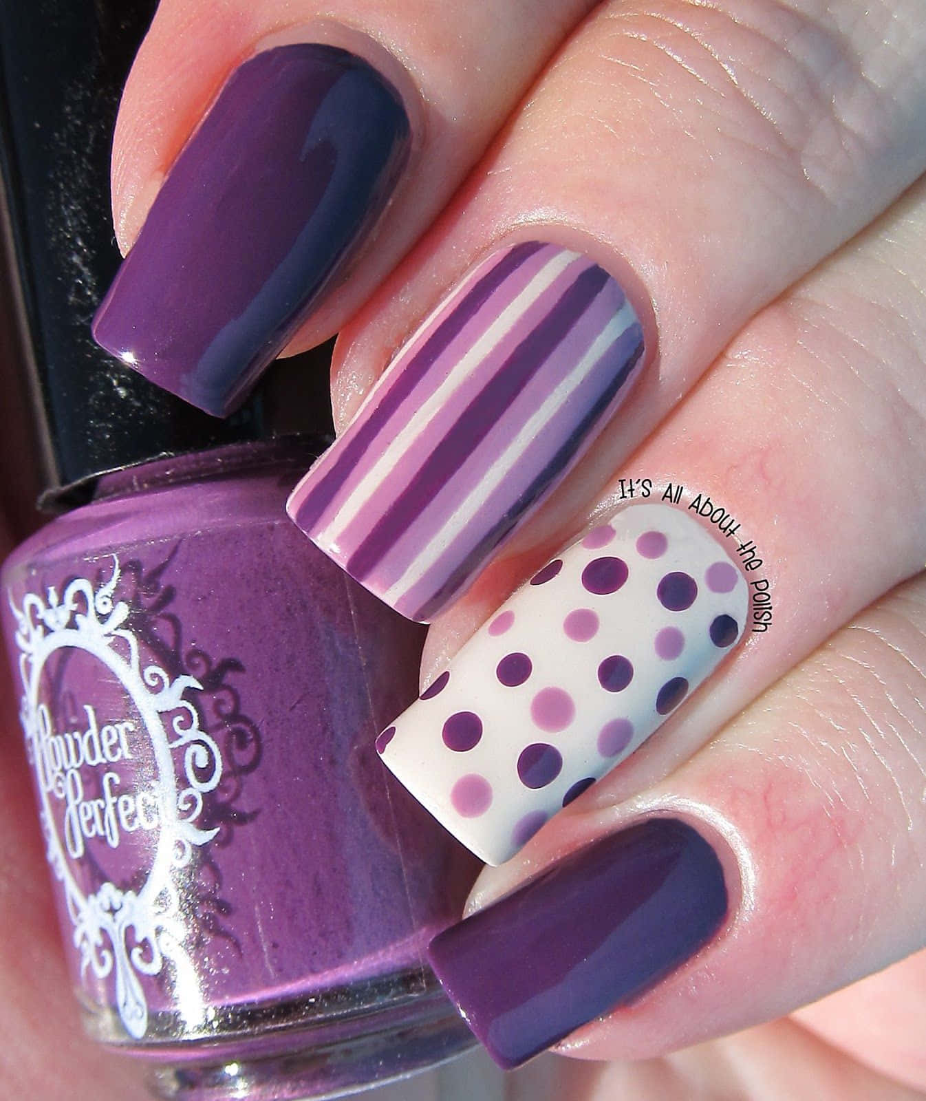 Nail 桌布 壁紙 — 手部特寫，帶有紫色條紋和圓點圖案的美甲，旁邊有一瓶相配的紫色指甲油。