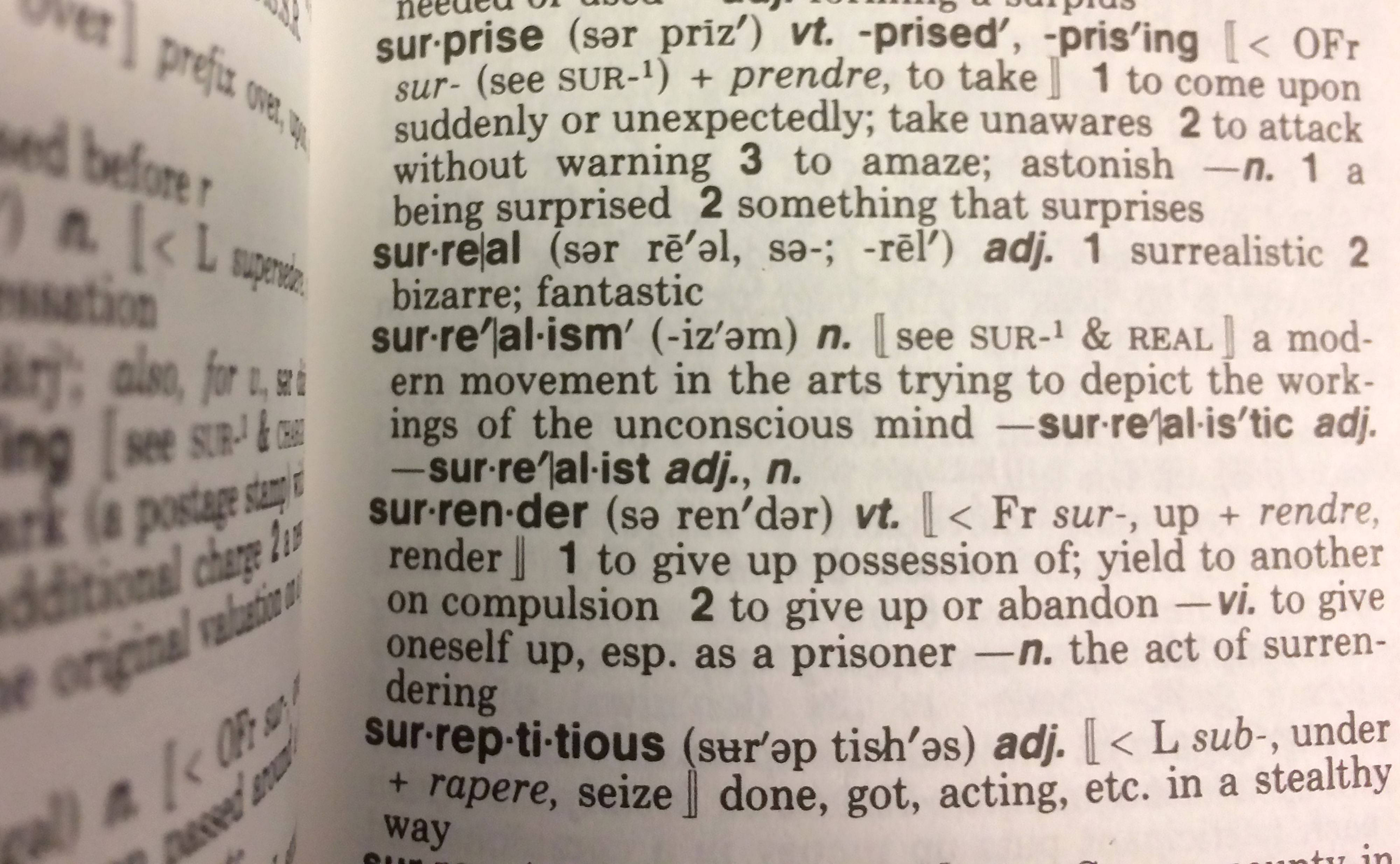 Dictionary 桌布 壁紙 — 打開字典頁面的特寫，顯示 surprise、surrealism 和 surrender 等詞語的定義，周圍文字模糊。