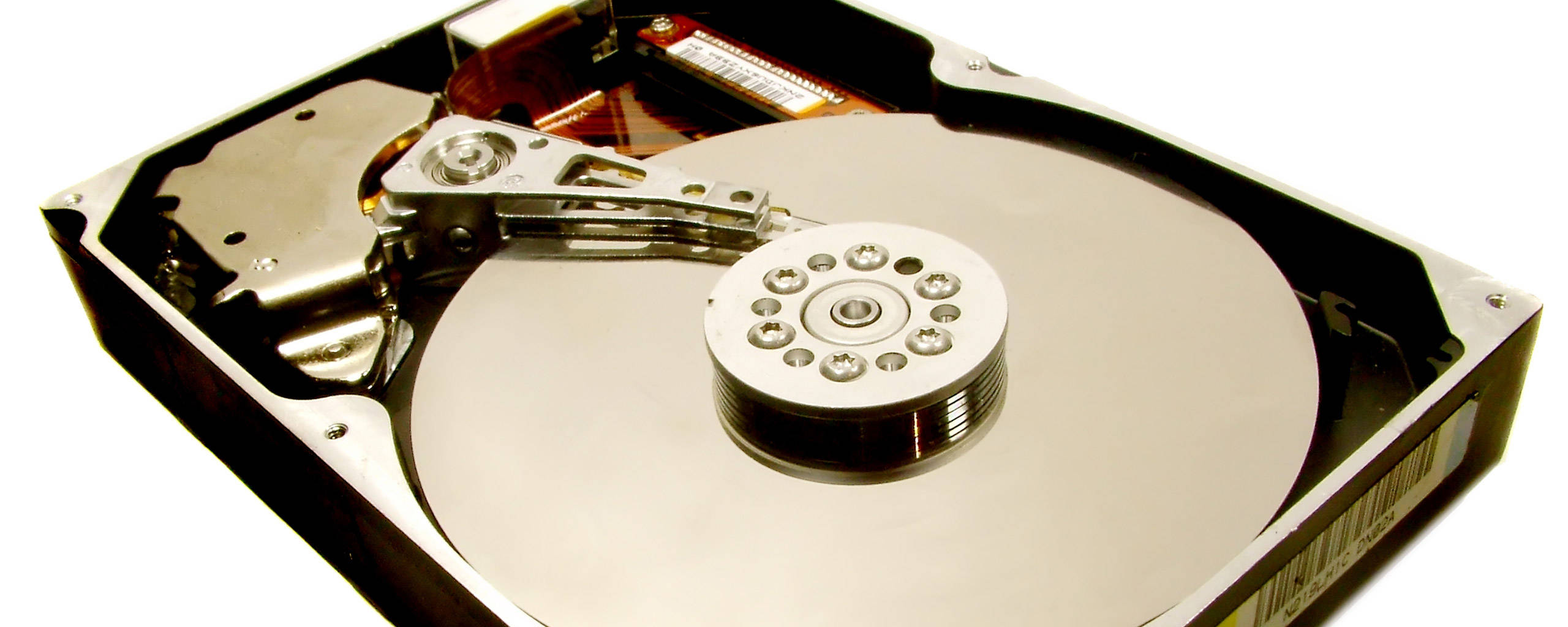 Hard Drive 桌布 壁紙 — 打開的硬碟驅動器的特寫，露出閃亮的碟片和讀寫臂，背景為白色。