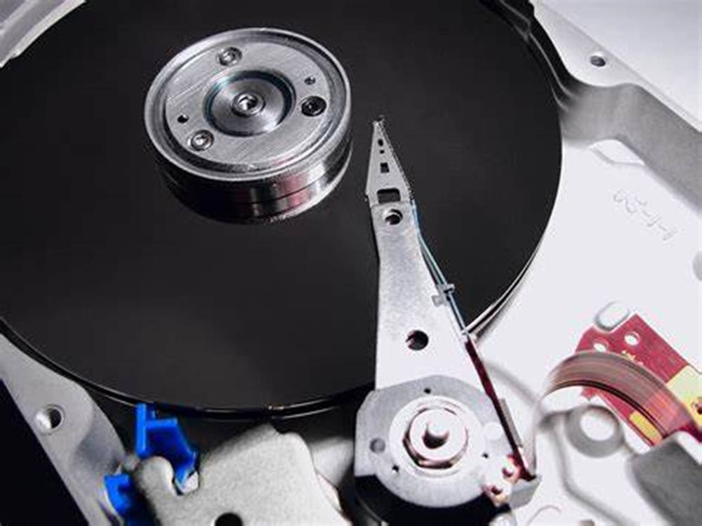 Hard Drive 桌布 壁紙 — 打開硬碟機的特寫，顯示旋轉碟片和讀寫臂，帶有金屬和黑色組件。