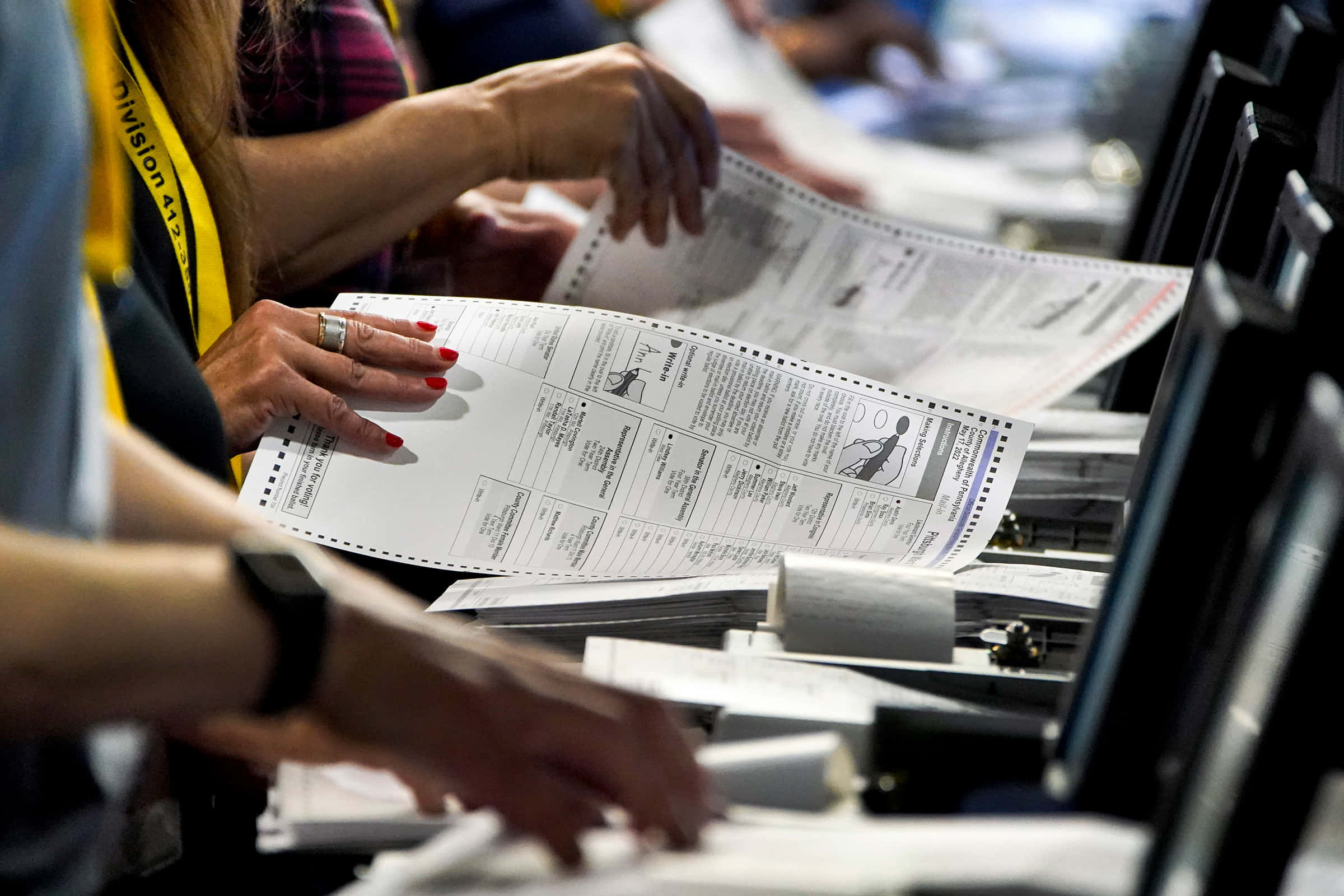 Election 桌布 壁紙 — 投票站內雙手專注精確地分類選票的特寫。