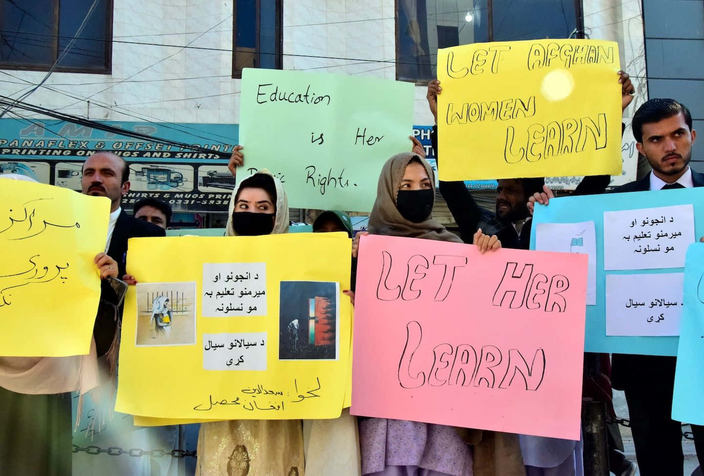 Taliban 桌布 壁紙 — 抗議者在街頭示威中舉起色彩繽紛的標語，要求為阿富汗女性提供教育。