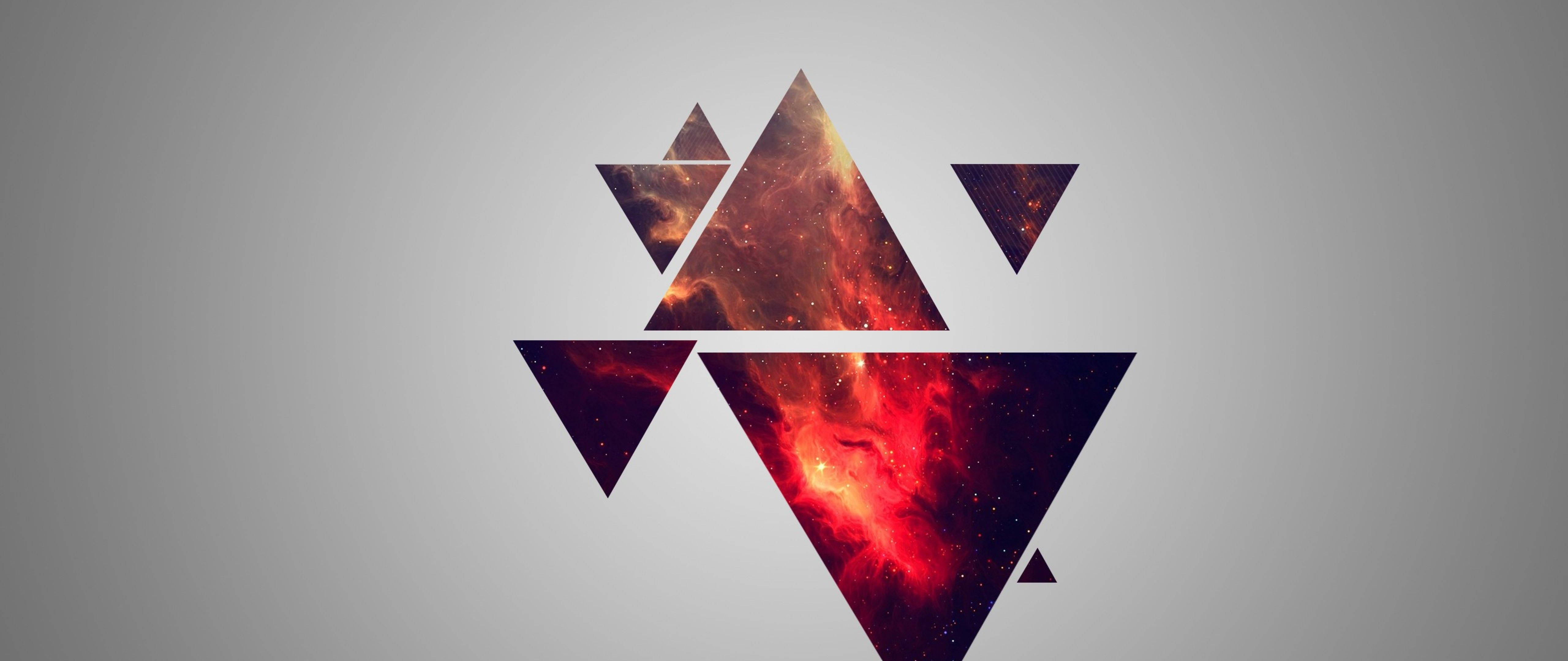 設計 桌布 壁紙 — 抽象幾何三角形充滿熾熱的宇宙星雲，背景為柔和的灰色漸變。