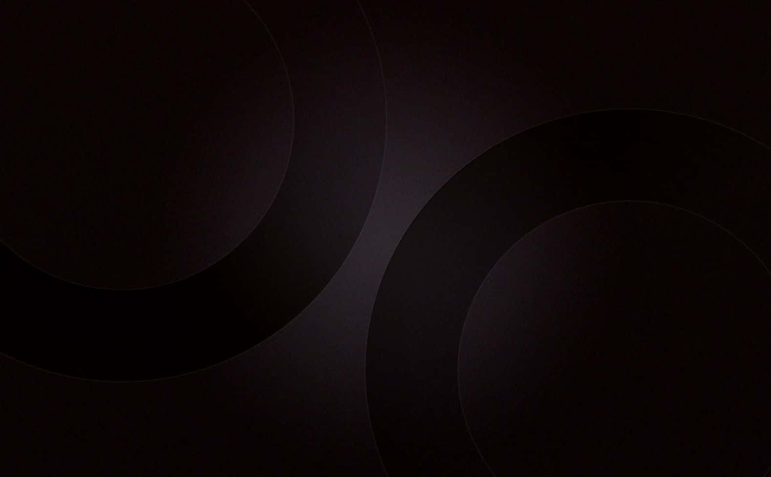 Black Solid 桌布 壁紙 — 抽象深色背景，帶有柔和發光的同心圓，營造出簡約寧靜的視覺效果。