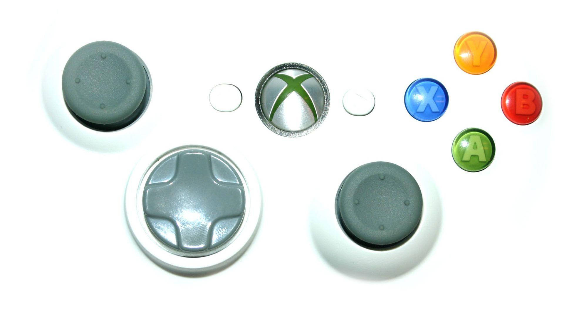 Xbox 桌布 壁紙 — 拆解的Xbox手把零件排列在白色背景上，顯示按鈕、搖桿和標誌。