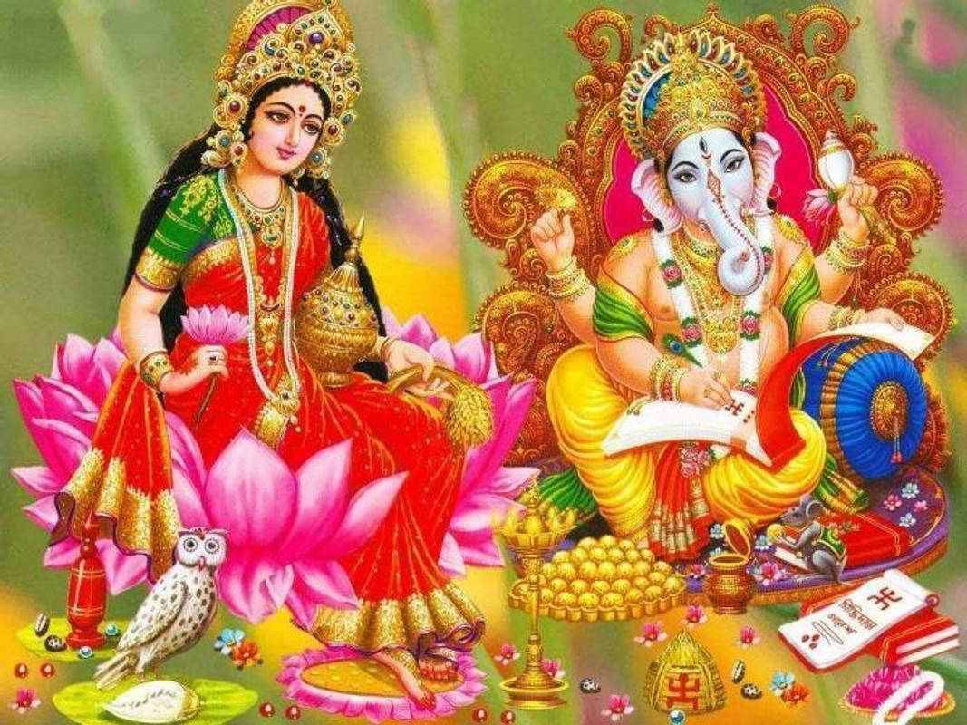 Lakshmi 桌布 壁紙 — 拉克什米女神和象頭神迦內什莊嚴地坐著，身著鮮豔的金色和紅色服飾，周圍環繞著蓮花、神聖符號和供品。