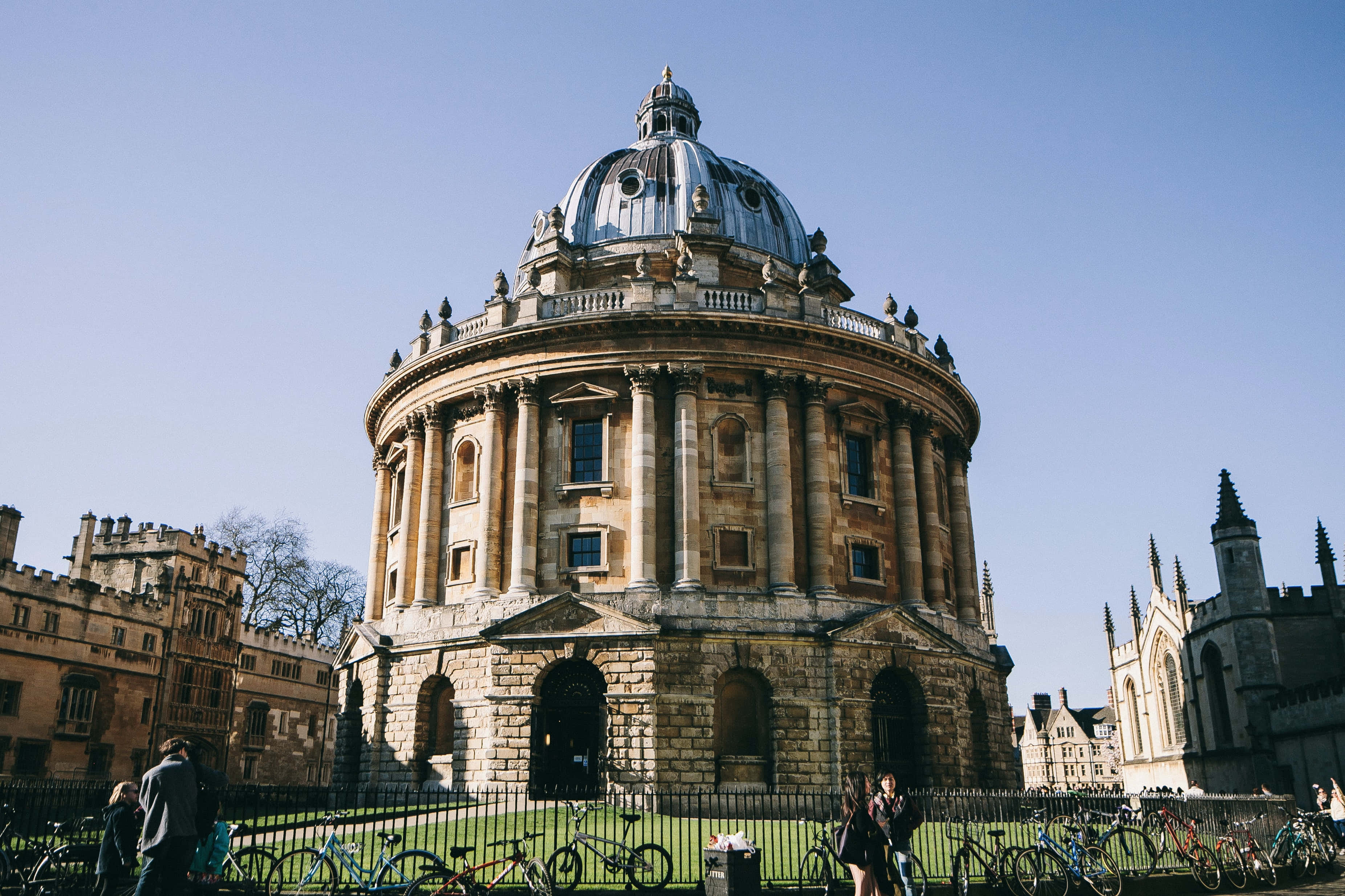 England 桌布 壁紙 — 拉德克利夫相機館的巨大石穹沐浴在明亮的陽光下，前景停放著自行車。