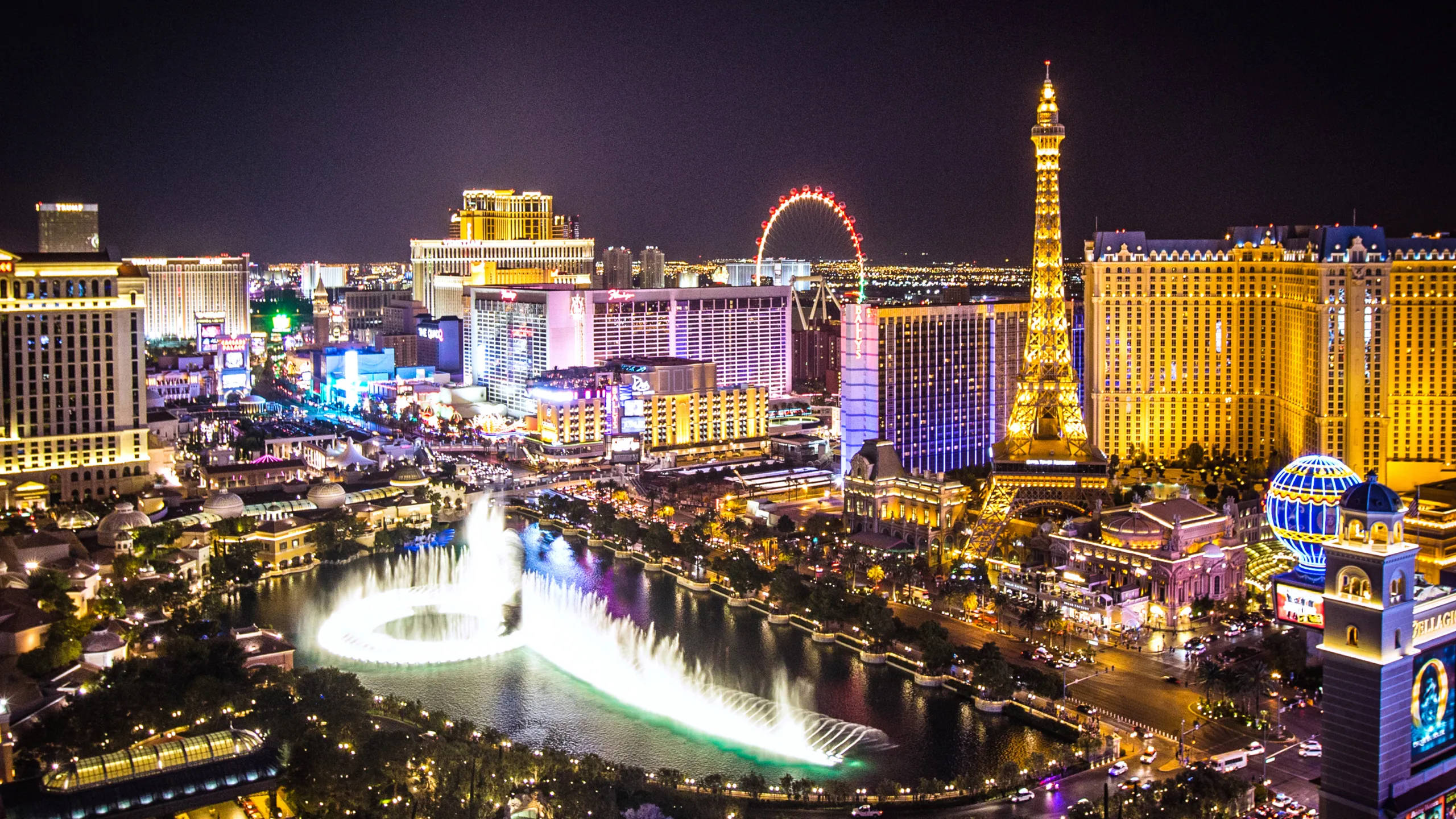 Las Vegas 桌布 壁紙 — 拉斯維加斯令人眼花繚亂的夜間鳥瞰圖，展示了燈火輝煌的噴泉和標誌性的複製艾菲爾鐵塔。