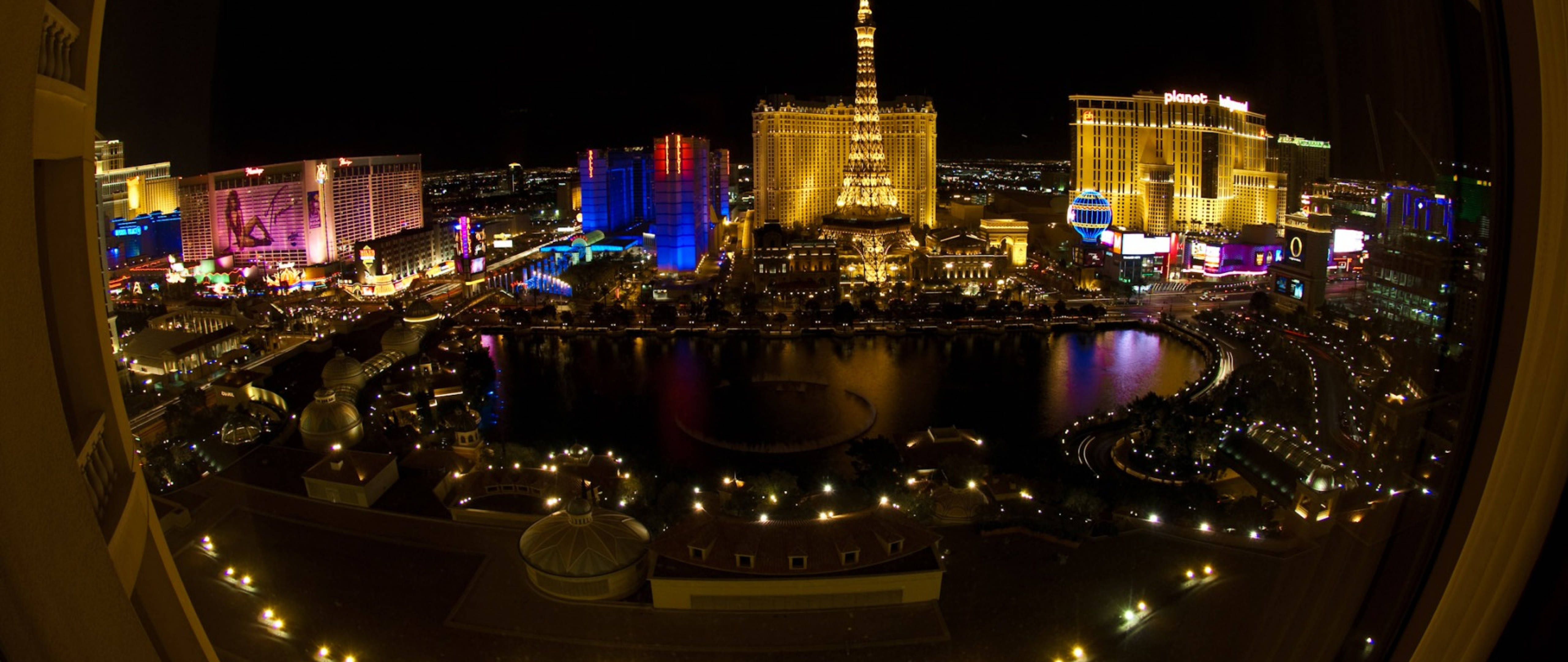 Las Vegas 4K 桌布 壁紙 — 拉斯維加斯夜晚的魚眼視角，中央水景反射著耀眼的霓虹燈光。