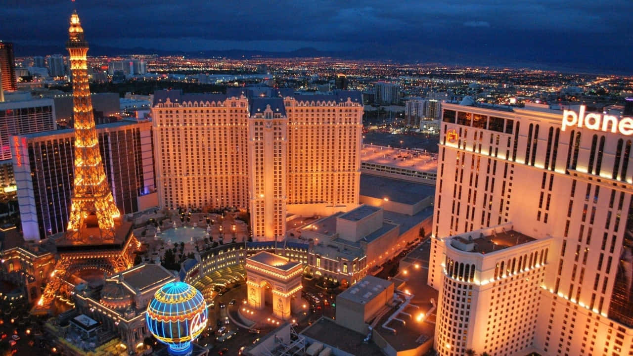720p Las Vegas 桌布 壁紙 — 拉斯維加斯夜景鳥瞰圖，漆黑的天空下，亮燈的艾菲爾鐵塔複製品和發光的酒店塔樓。