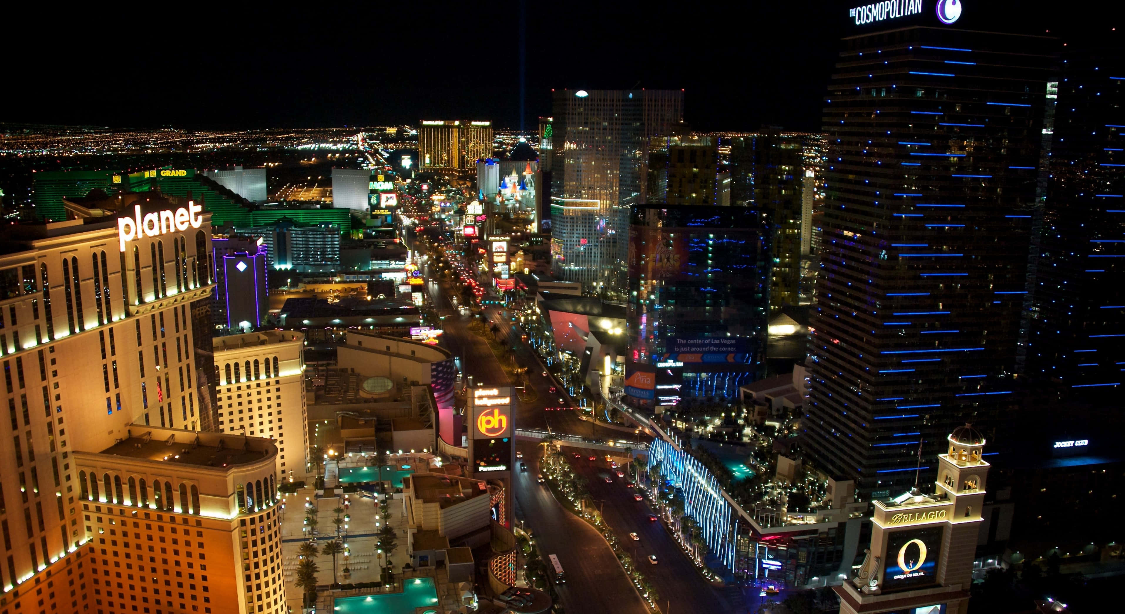 4K Las Vegas 桌布 壁紙 — 拉斯維加斯大道令人驚嘆的夜間鳥瞰圖，霓虹燈閃爍的酒店和繁華的街道。