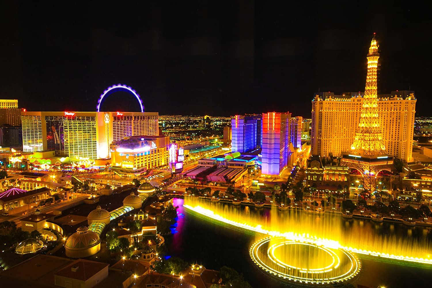 Las Vegas Skyline 桌布 壁紙 — 拉斯維加斯大道充滿活力的夜景，在黑暗的天空下閃耀的噴泉和標誌性酒店。