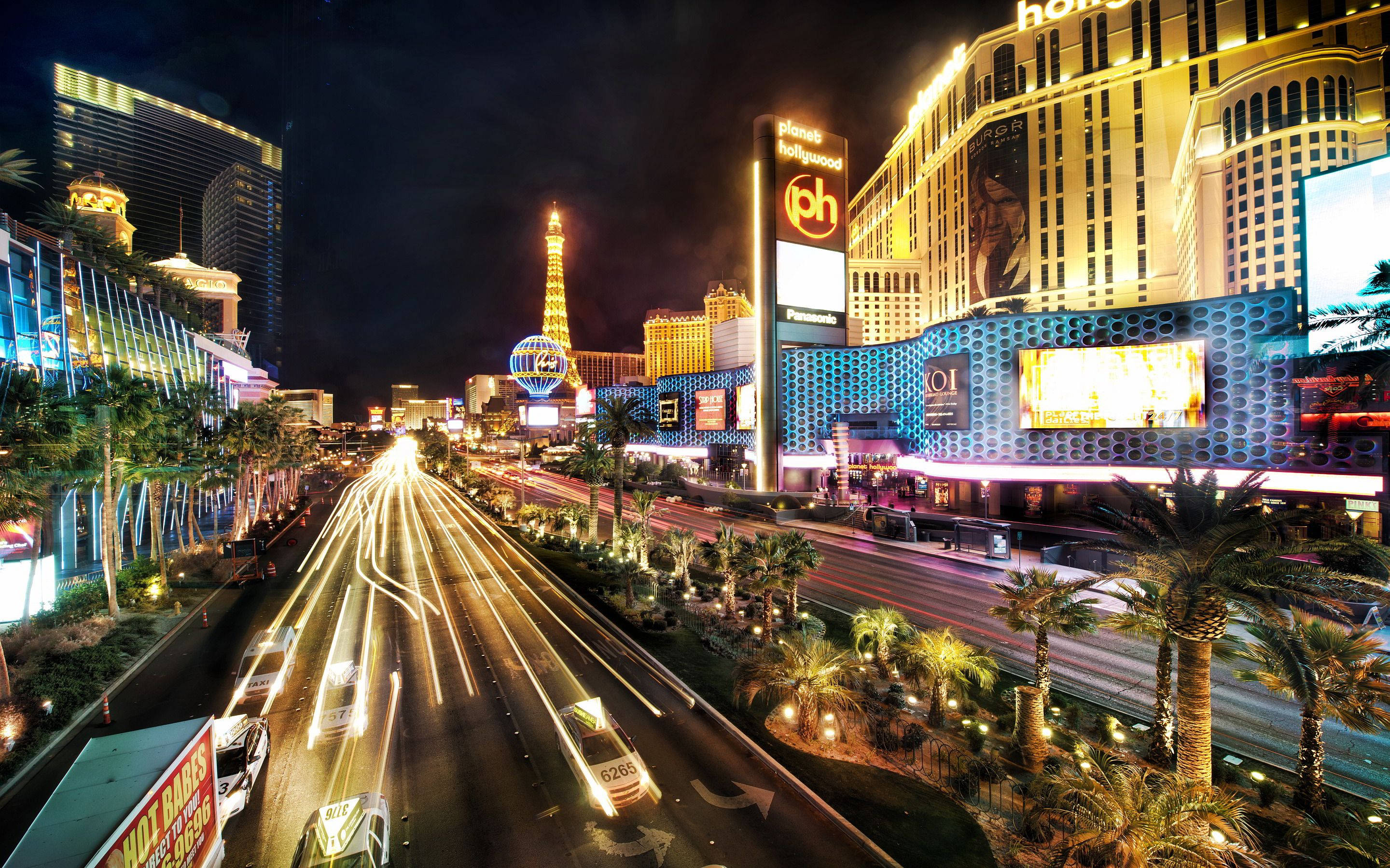 Las Vegas 桌布 壁紙 — 拉斯維加斯大道充滿活力的夜景，帶有拖曳的車燈和發光的賭場外牆。