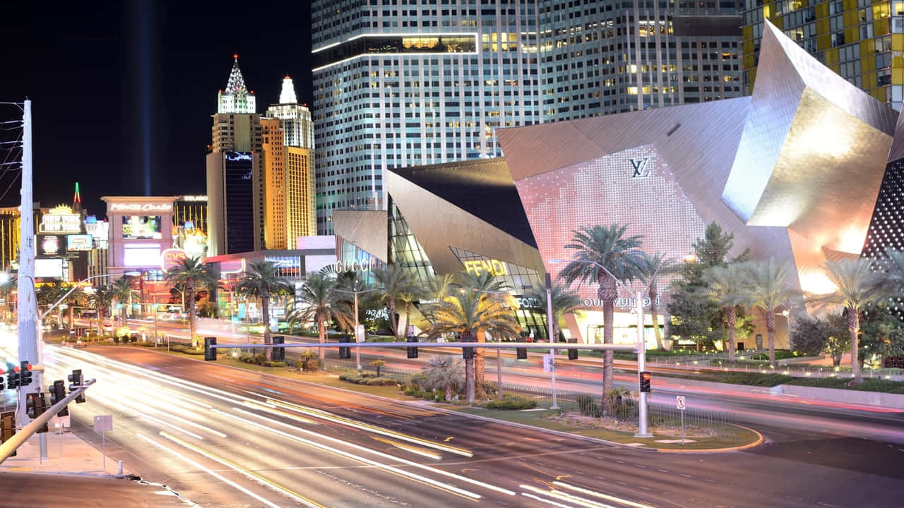 720p Las Vegas 桌布 壁紙 — 拉斯維加斯大道充滿活力的夜景，閃爍的摩天大樓、棕櫚樹和行駛汽車的光跡。