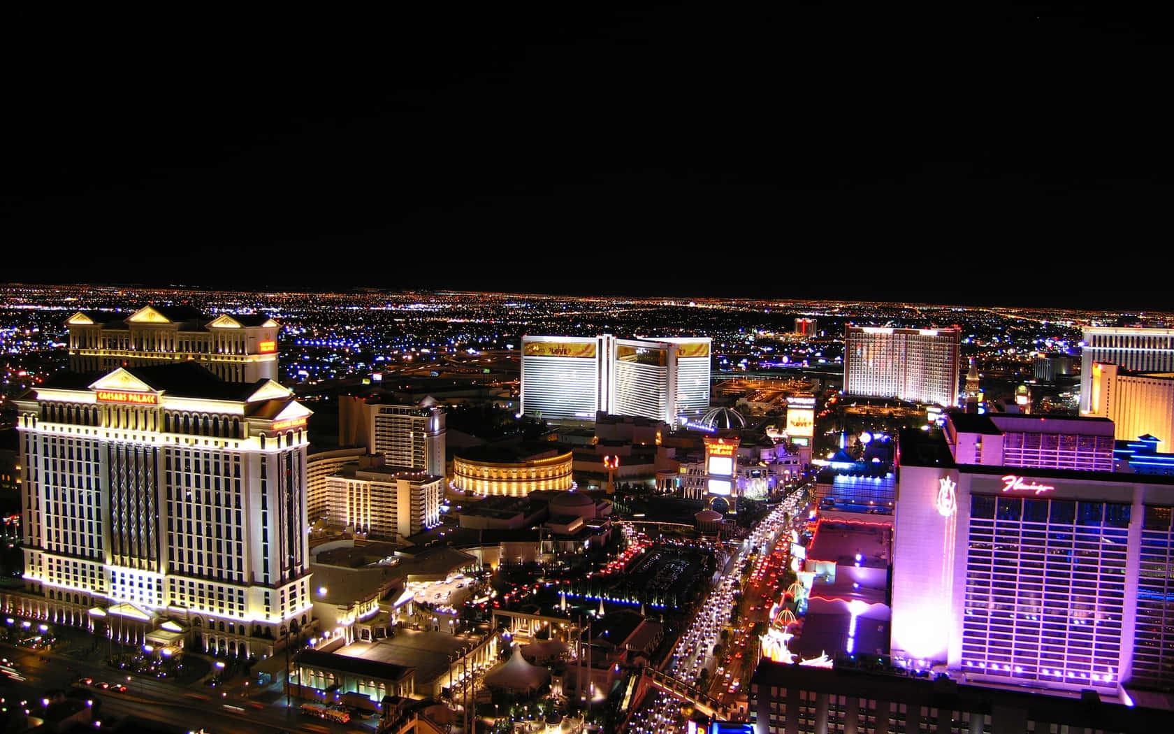 Vegas 桌布 壁紙 — 拉斯維加斯大道夜間璀璨的鳥瞰圖，霓虹燈閃爍的酒店和繁忙的街道。
