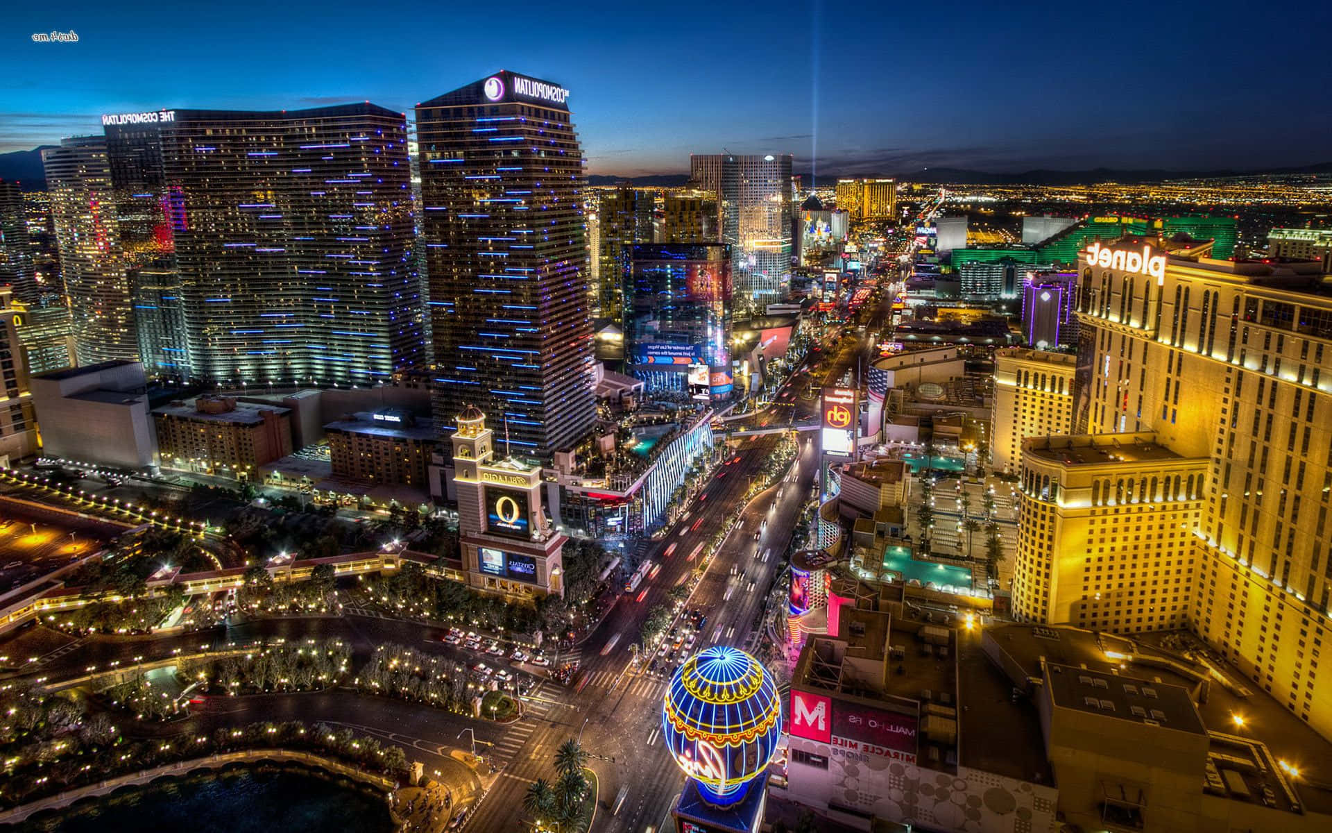 Las Vegas Skyline 桌布 壁紙 — 拉斯維加斯大道夜間航拍圖，閃爍的賭場和霓虹燈照亮了繁華的城市景觀。