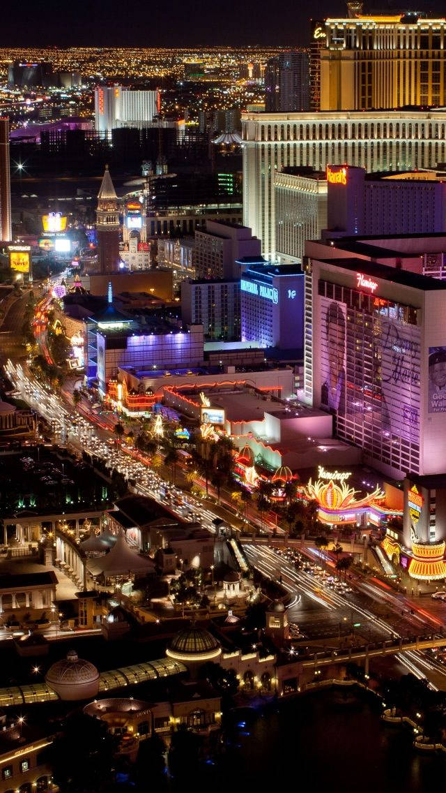Las Vegas 桌布 壁紙 — 拉斯維加斯大道夜間航拍景觀，在黑暗天空下閃爍著霓虹燈光和車流。