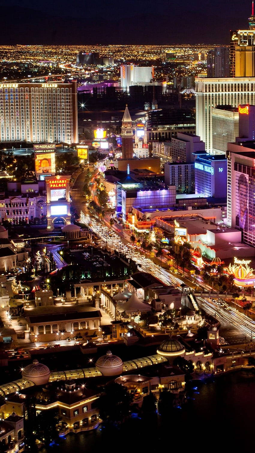 Vegas iPhone 桌布 壁紙 — 拉斯維加斯大道夜間鳥瞰圖，在黑暗的天空下閃爍著霓虹燈和繁忙的交通。