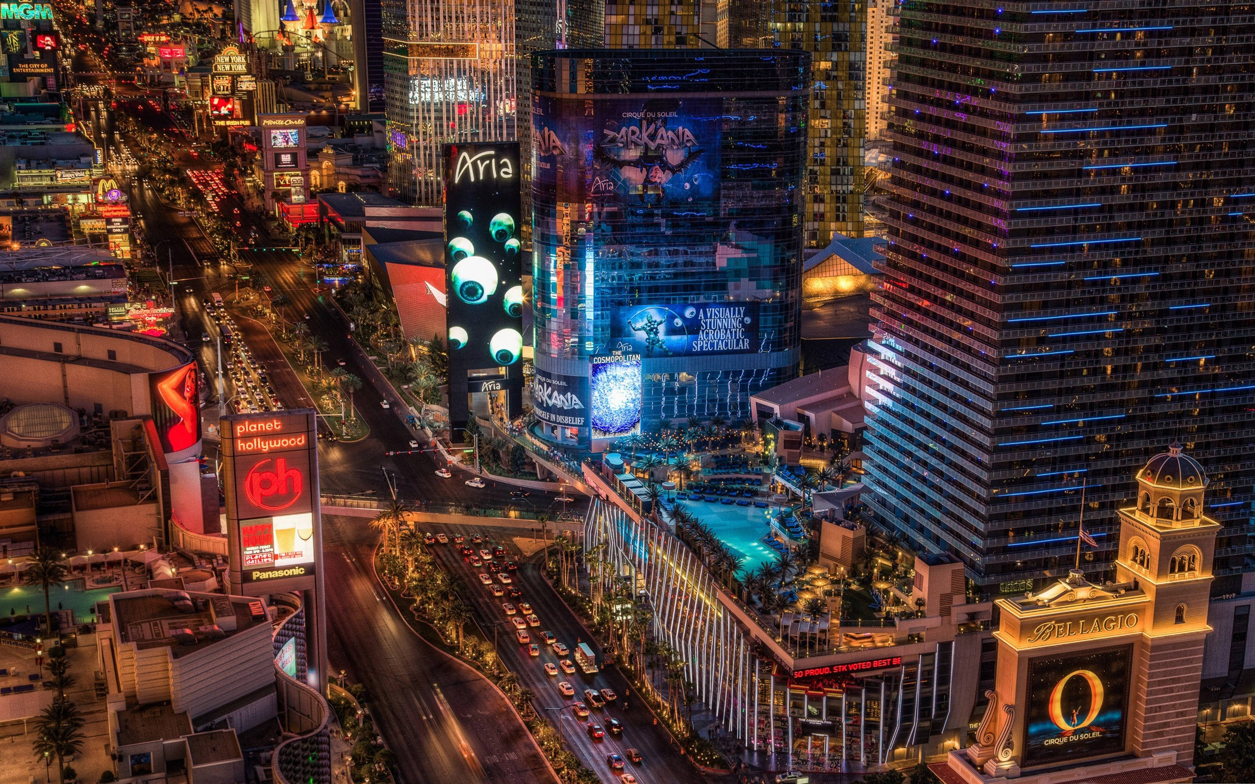 Las Vegas 桌布 壁紙 — 拉斯維加斯大道夜間鳥瞰圖，閃爍的賭場招牌和繁忙的交通穿梭於高聳的飯店之間。